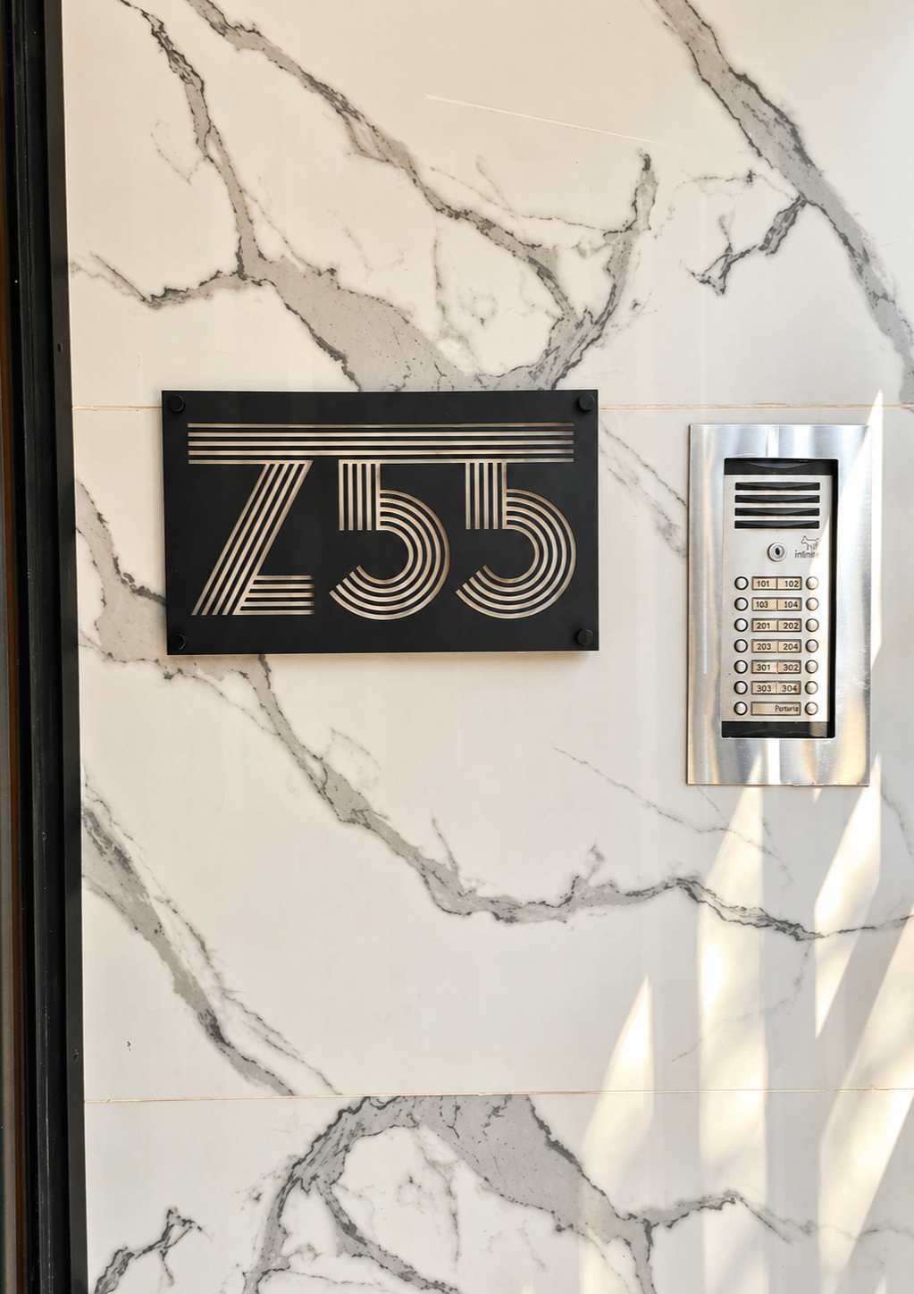 Building exterior with black house number sign 'Z55' and intercom system on a marble wall.