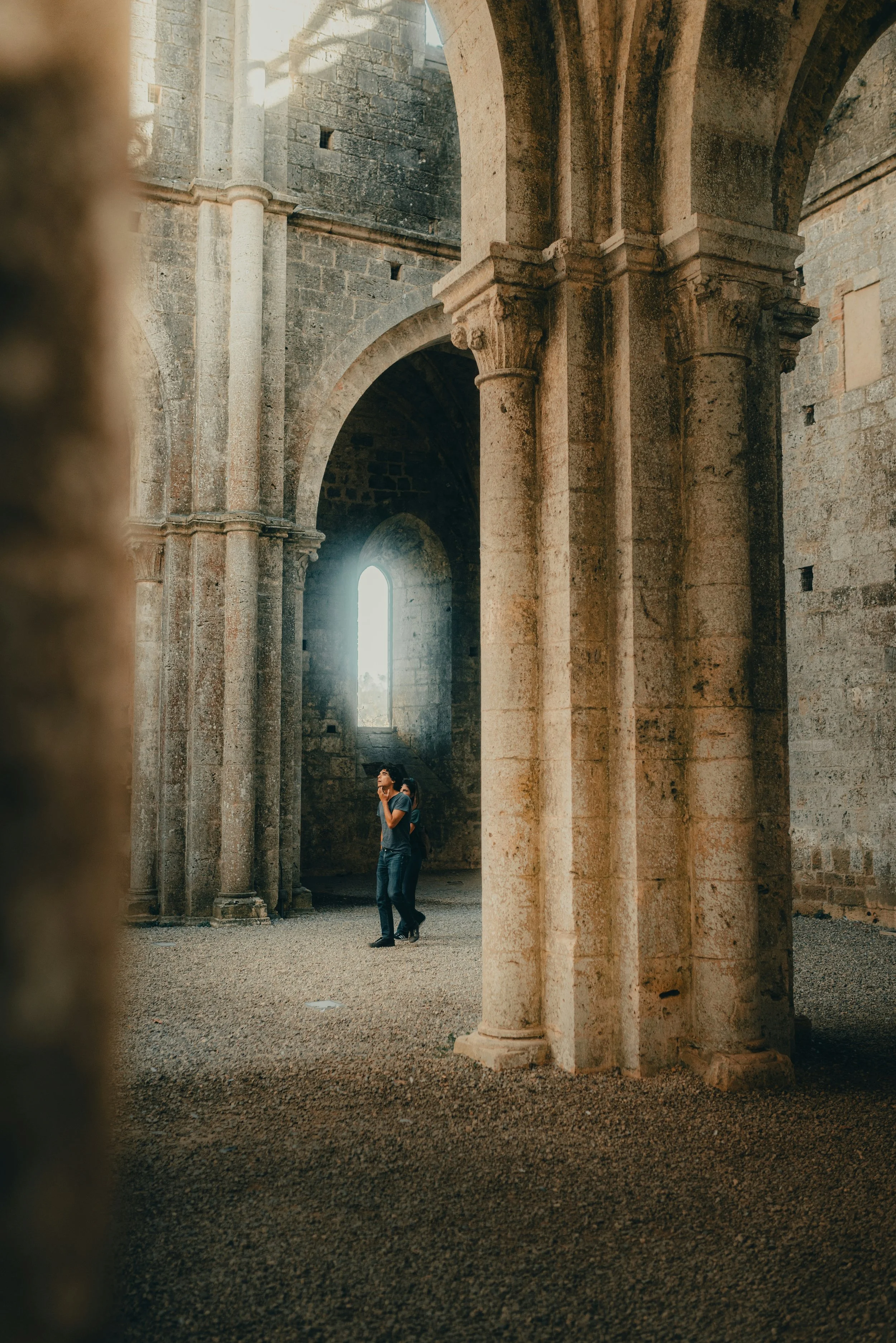A person standing in an old building with columns