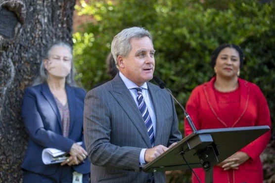 SFPUC’s General Manager at an outdoor podium with two people standing behind.