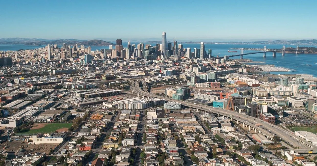 Wide aerial view of San Francisco with downtown skyline and freeways.