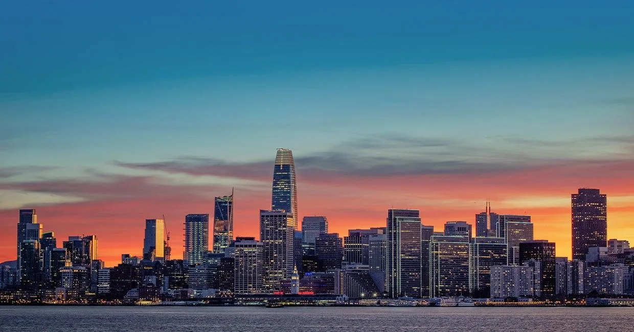 San Francisco skyline at sunset with vibrant orange and blue sky.