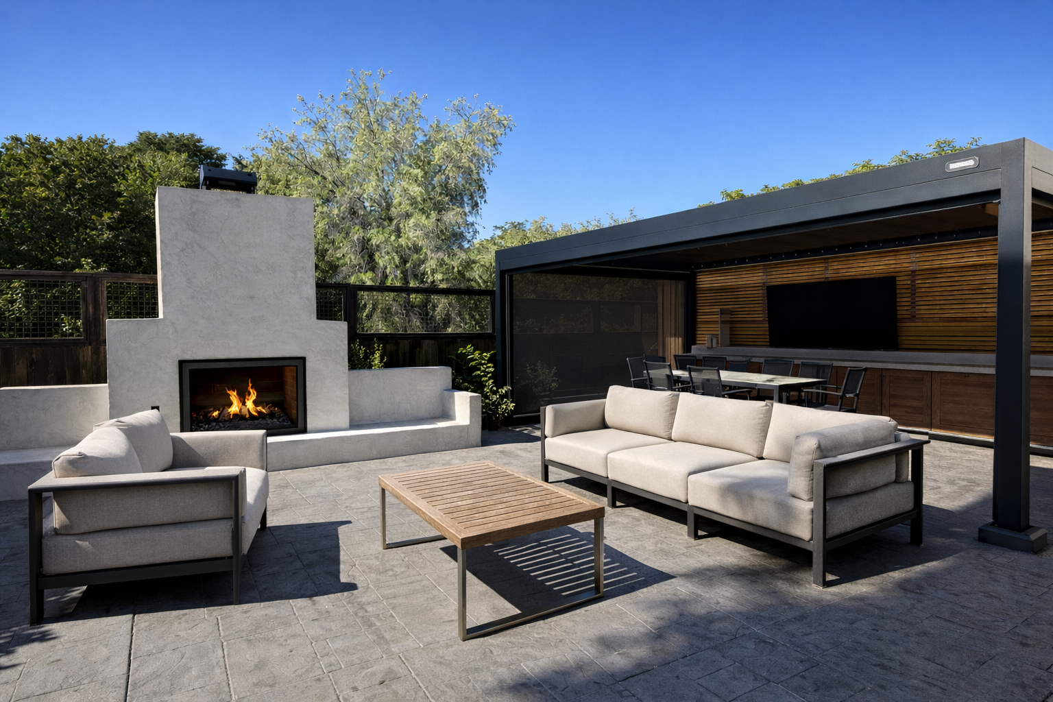 Outdoor patio with a modern fireplace, beige outdoor sofas, a wooden coffee table, a covered dining area, and lush greenery in the background.