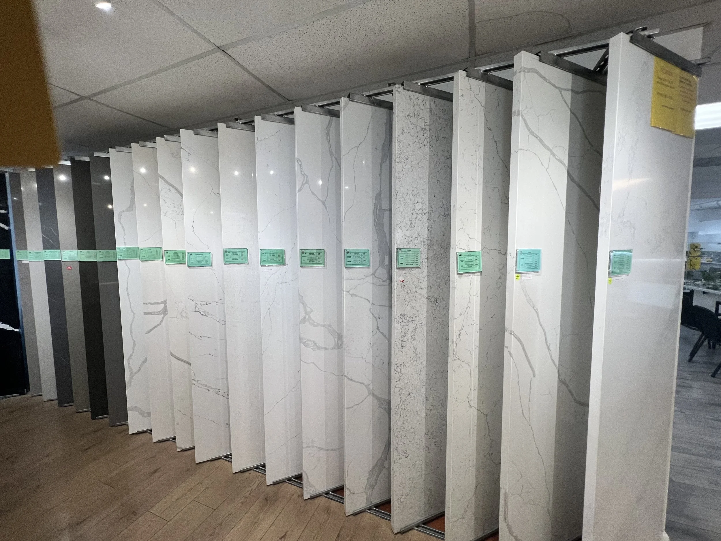 A display of marble and stone slabs in various shades and patterns on vertical panels in a showroom.