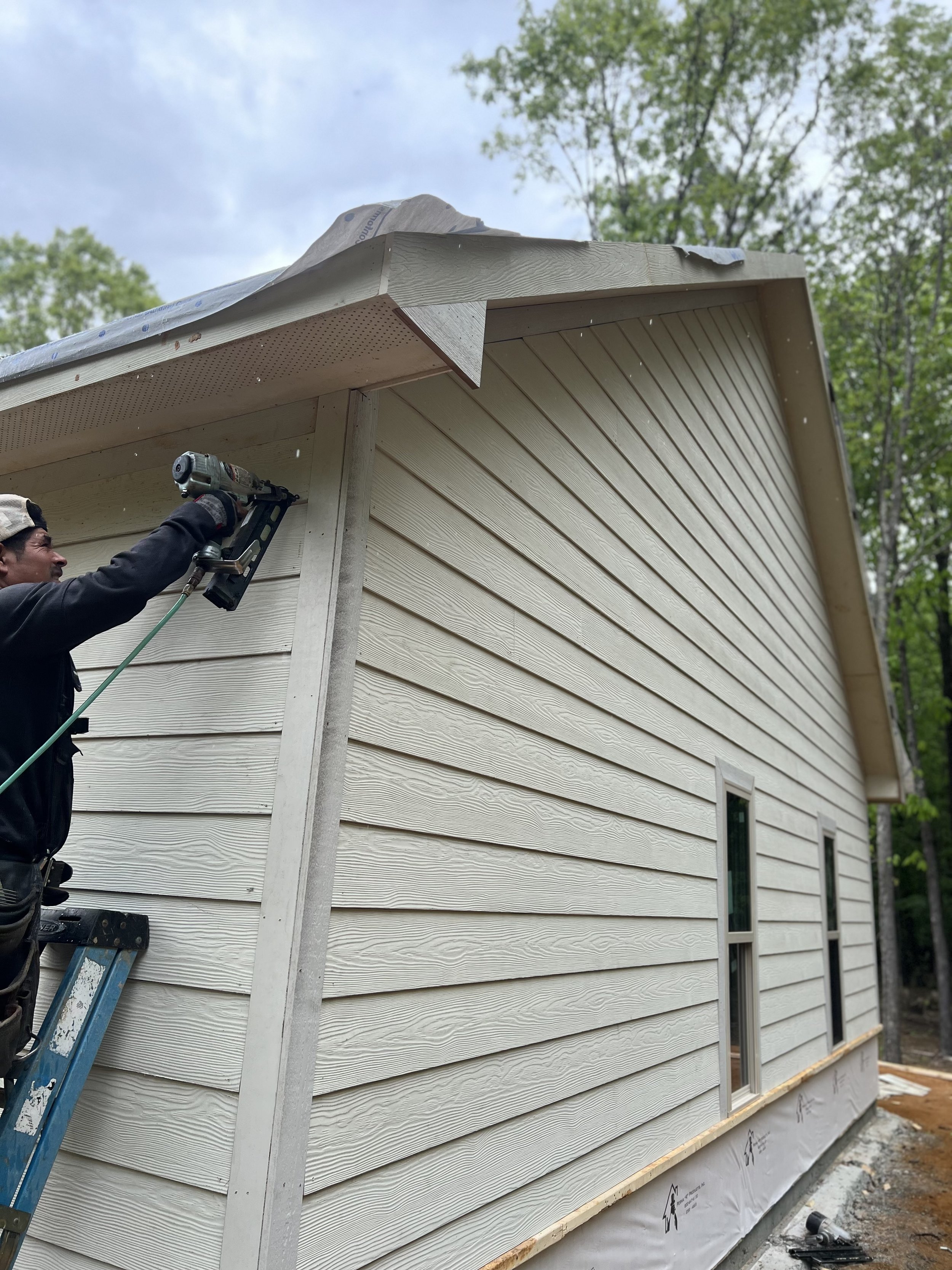 Man nailing down Siding