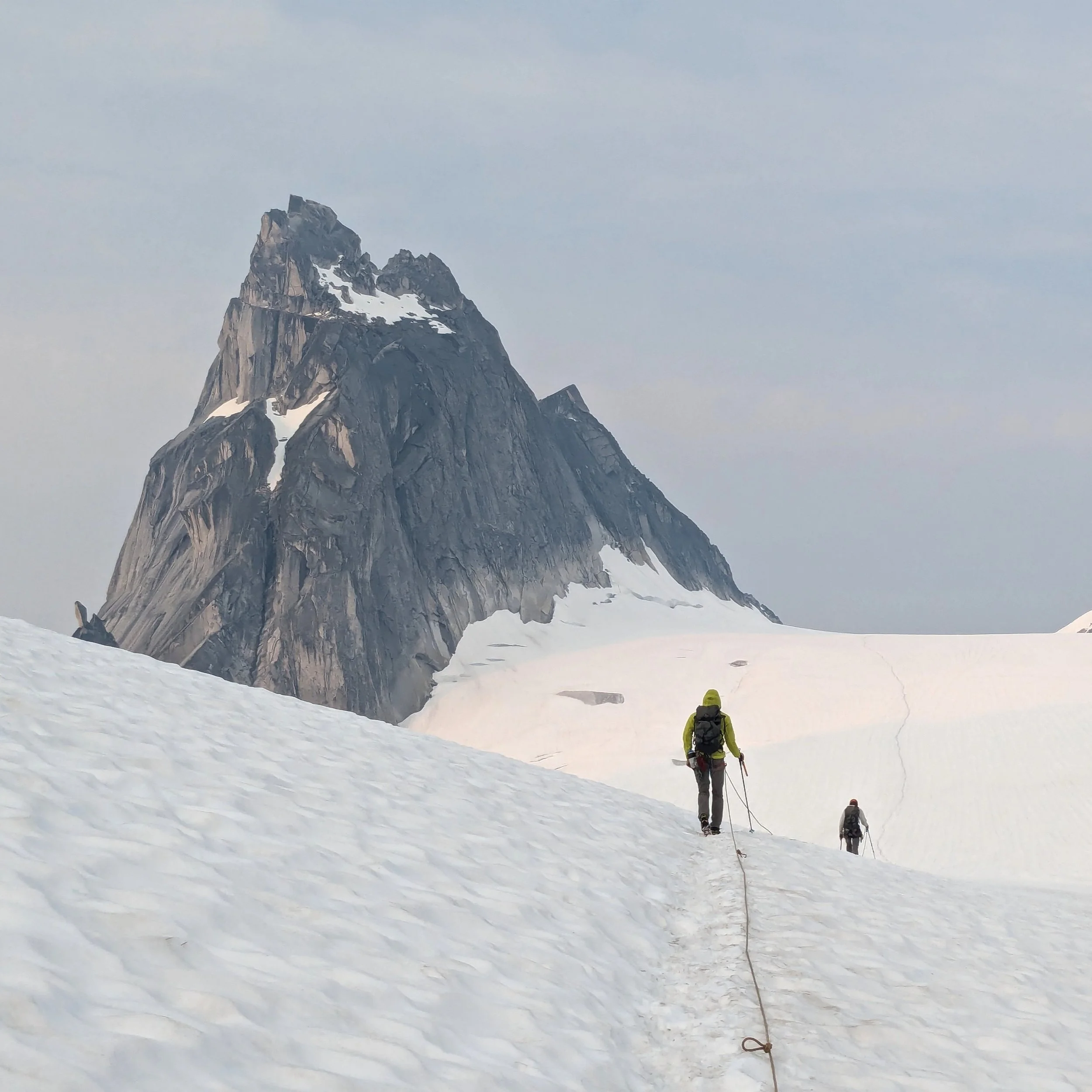 Michael, the photographer behind Wandering Sole Studios, walking on a glacier in Bugaboos Provincial Park in British Columbia. The climbers are walking towards a granite spire.