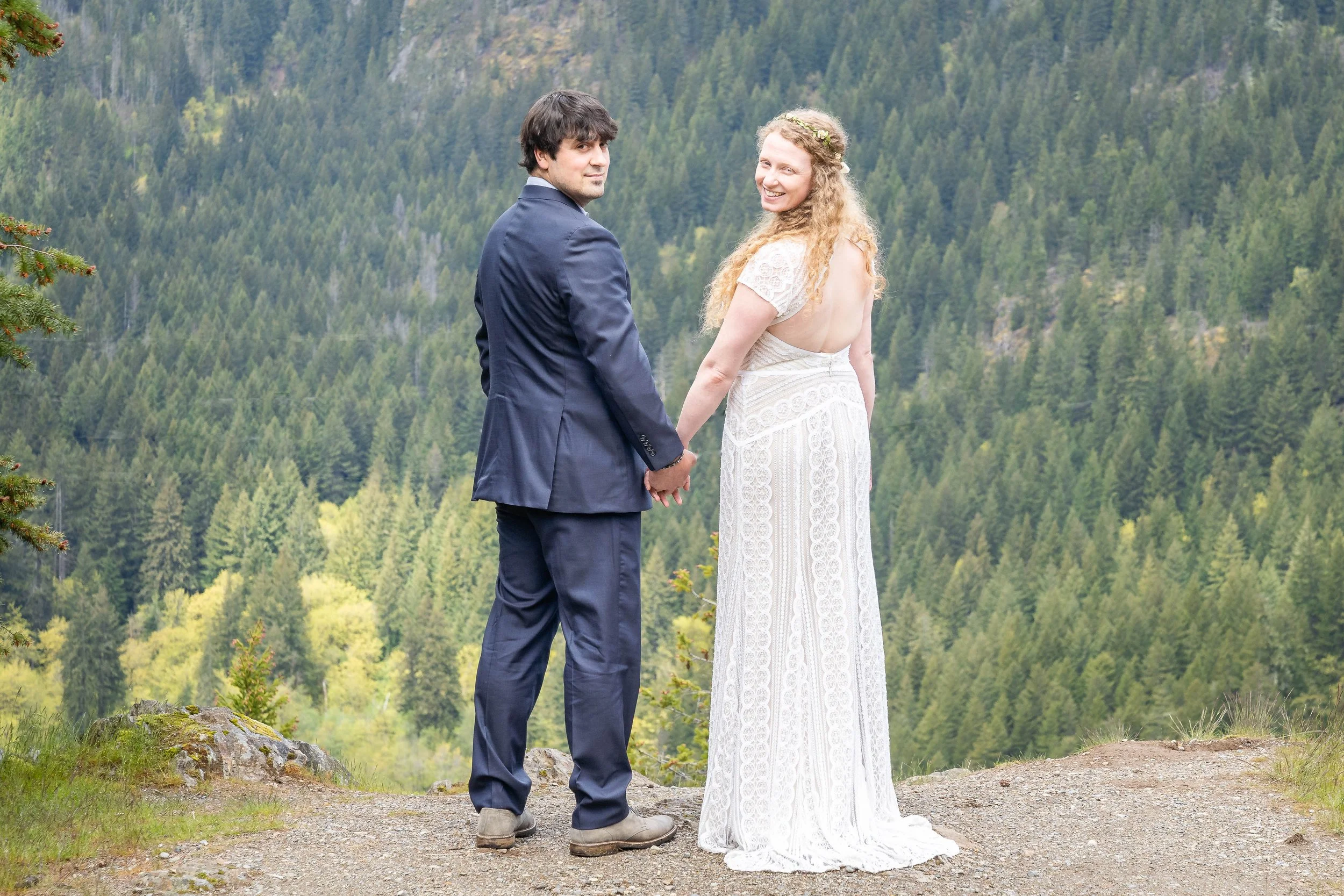 A couple holding hands and turning back to look at the camera during a North Cascades elopement near Diablo Lake.