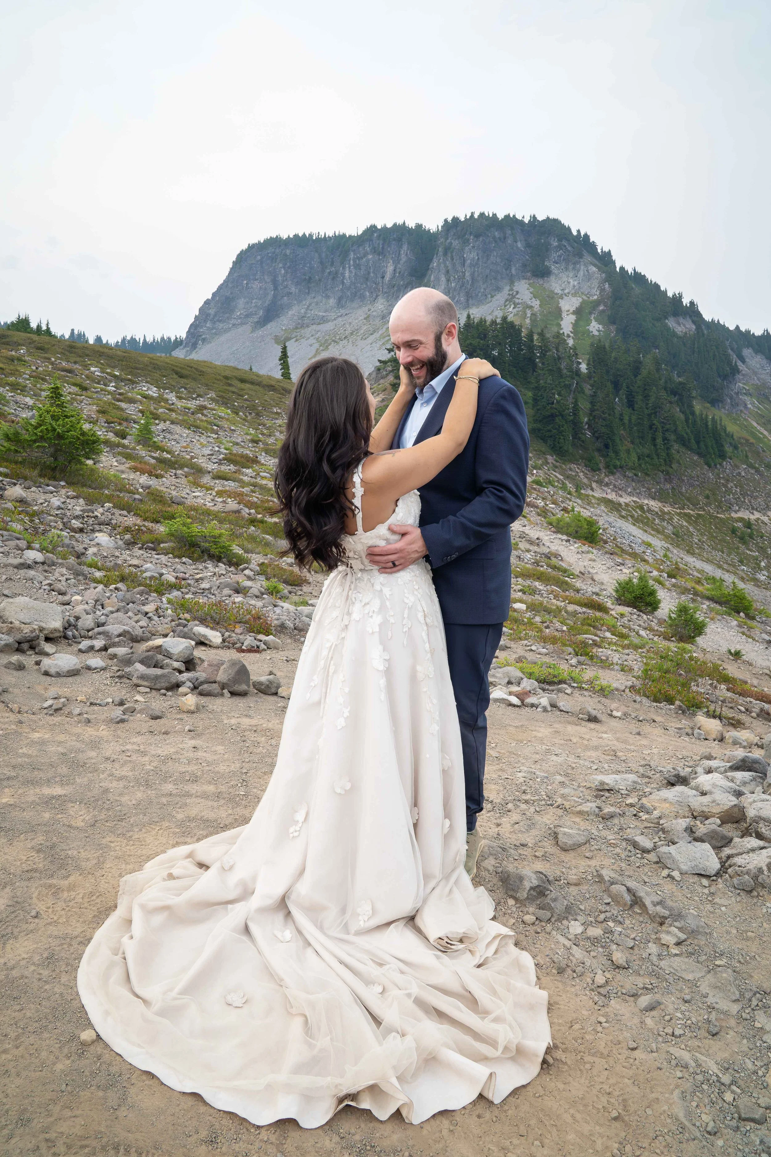 A bride and groom holding their first dance in an alpine meadow on Ptarmigan Ridge during their Mt. Baker elopement, with Table Mountain in the background.
