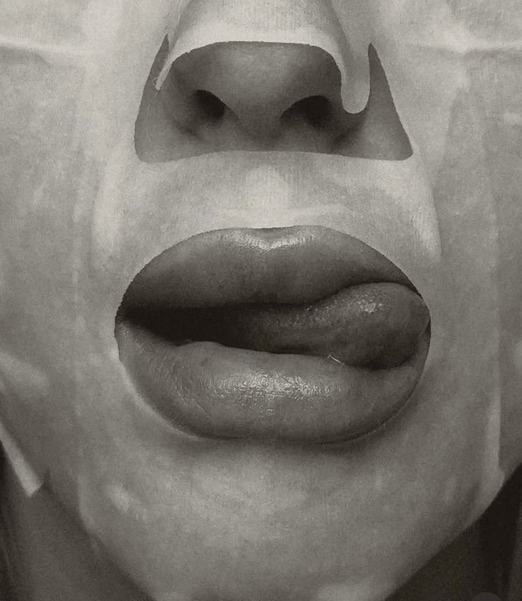 Close-up of a person's face with the mouth slightly open, tongue sticking out, and a nose visible at the top.