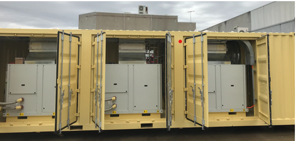 Open yellow shipping container fitted with electrical equipment and panels.