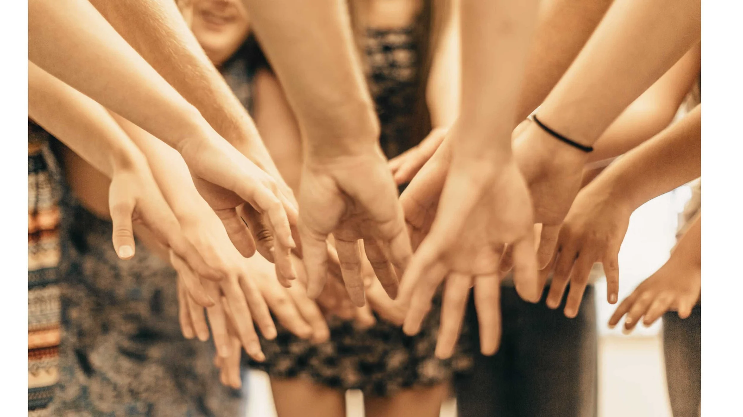 Groupe de plusieurs mains tendues et jointes, symbolisant l'unité ou la solidarité.