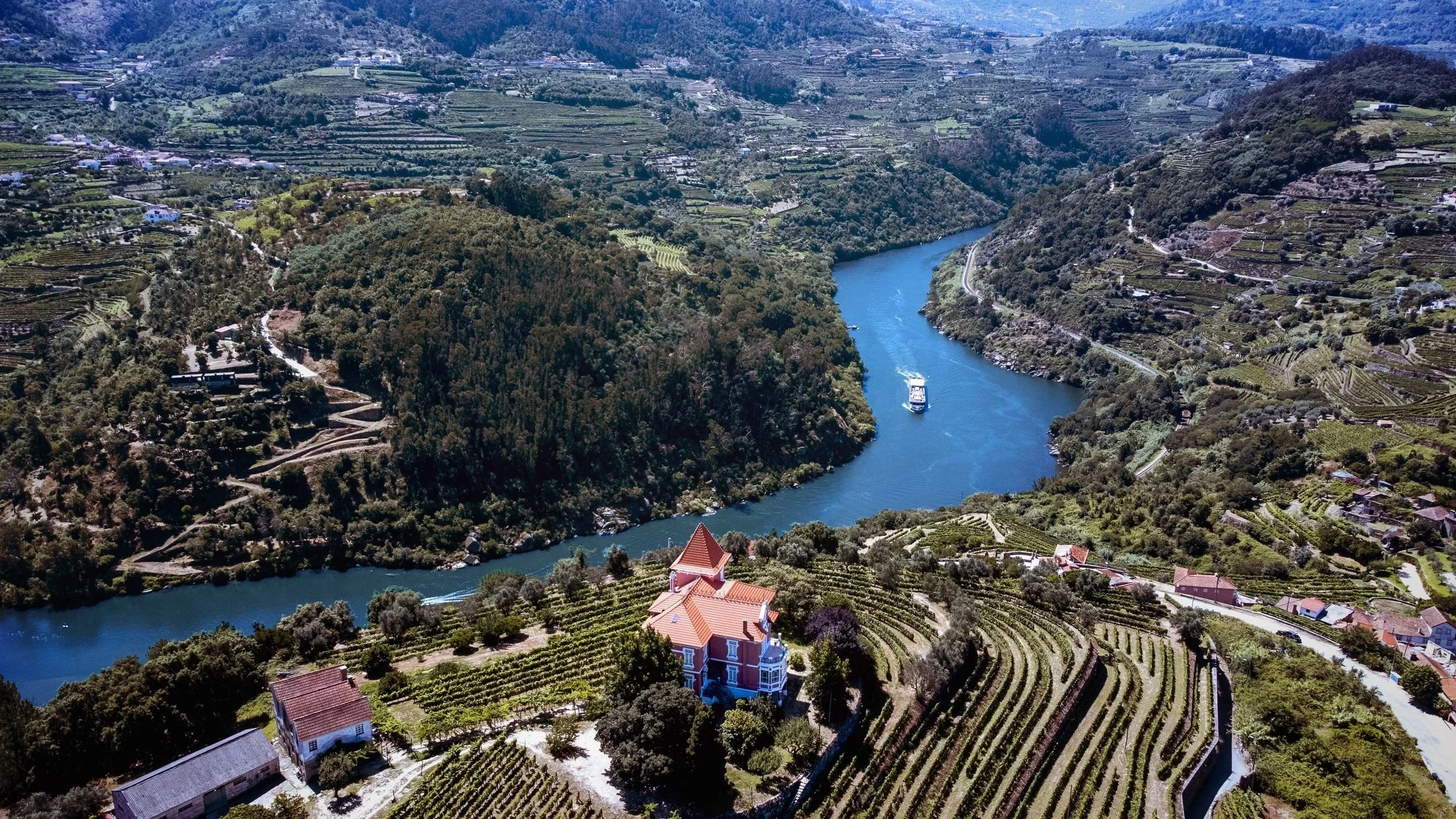 AmaVida, an AmaWaterways river boat, sailing through a winding valley on the Douro River