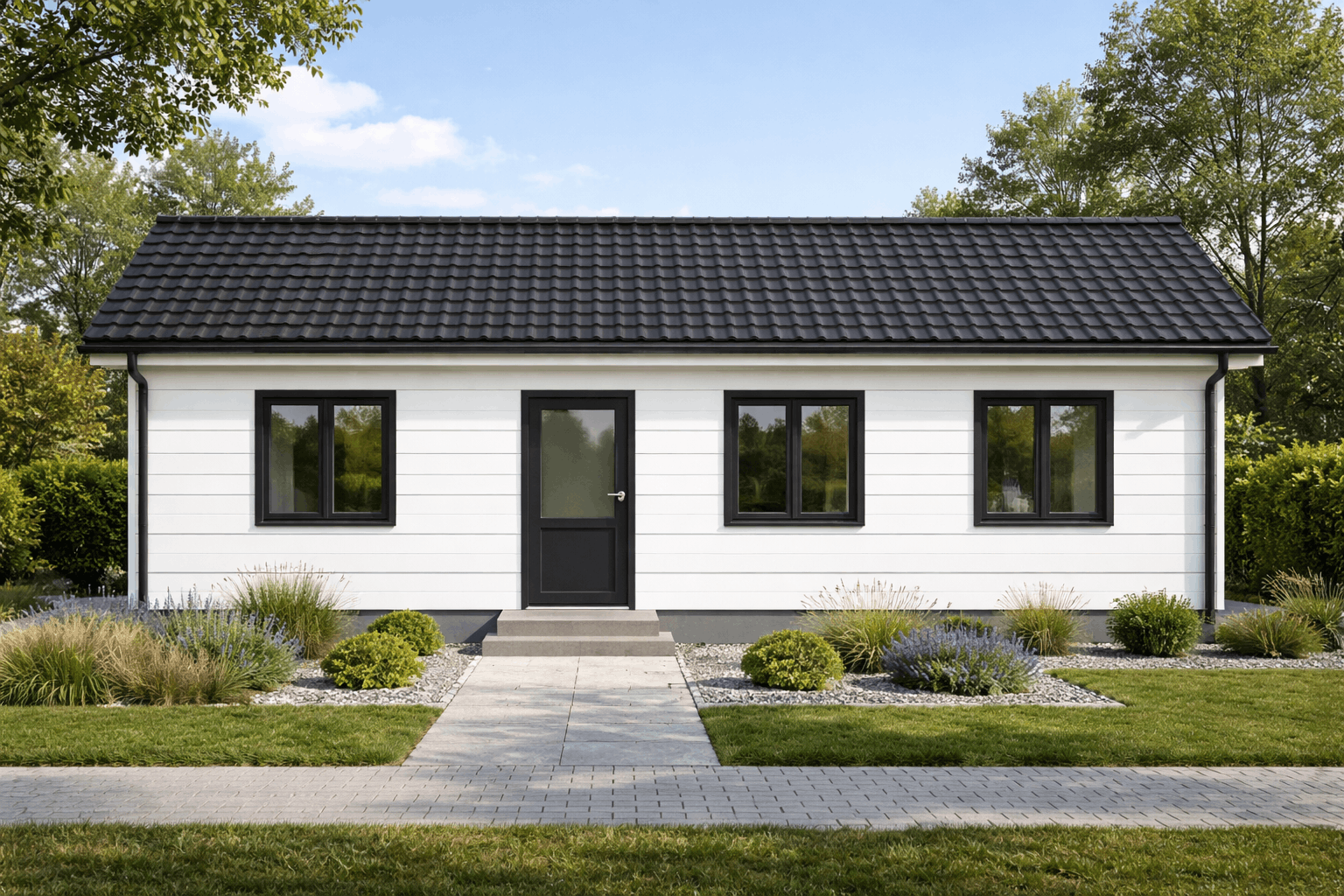 Front view of a small white house with black trim, three windows, a black door, and surrounding landscaping with grass, plants, and a paved walkway.