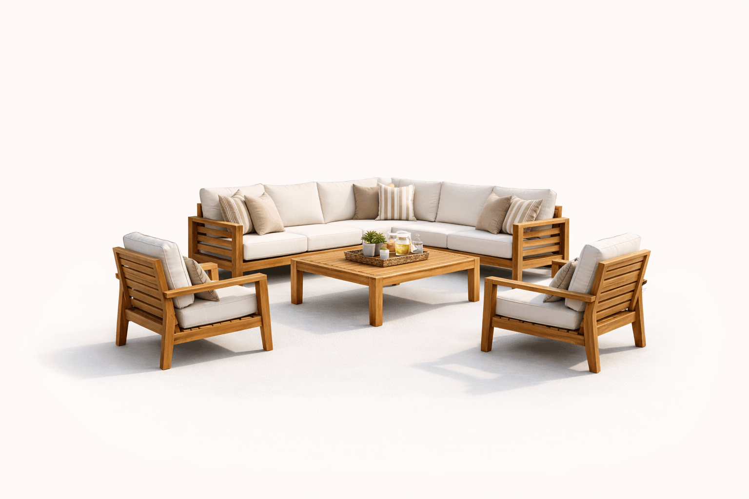Living room with a large beige sectional sofa and three matching armchairs, all with wooden frames and cushions. A wooden coffee table with a tray holding a small plant, drinks, and a pitcher is in the center. The background is plain white.