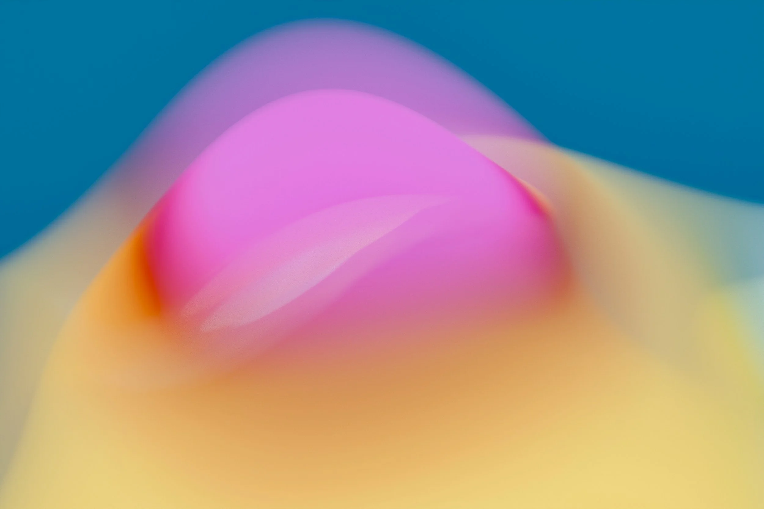 Abstract colorful blurred background with pink, yellow, and purple hues.
