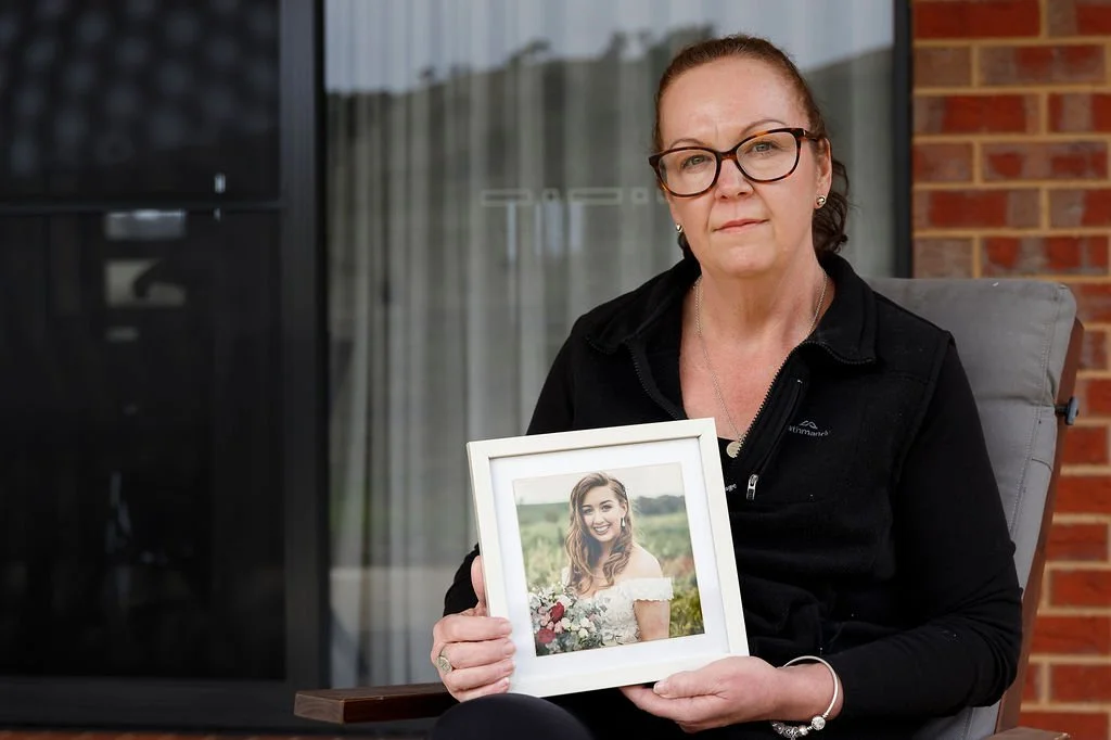 Leanne holding a framed photograph of her sister Ellie, who was diagnosed with a rare cancer at 24