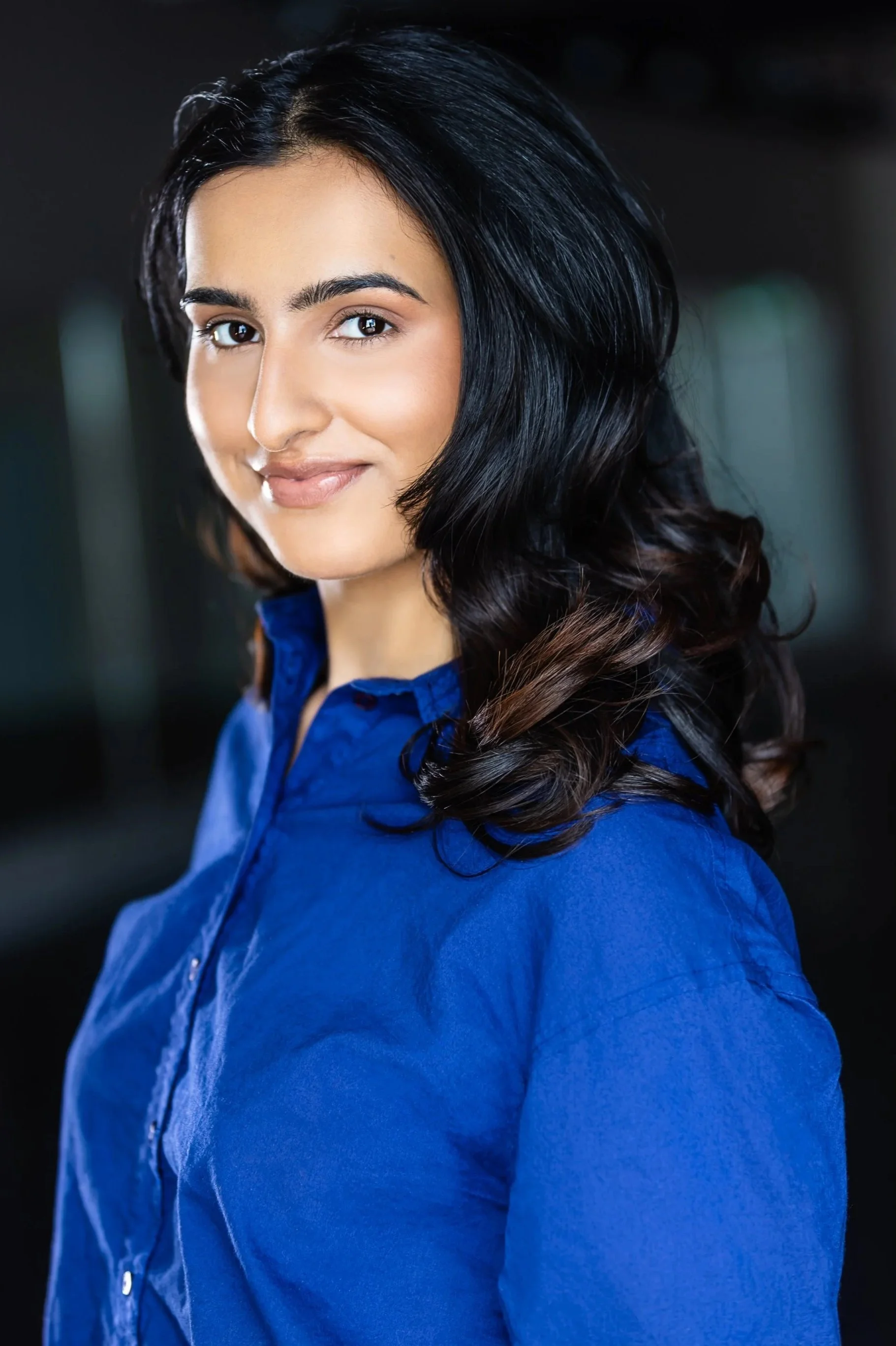 Uma Bains, a young South Asian actress with dark hair and eyes in a royal blue top