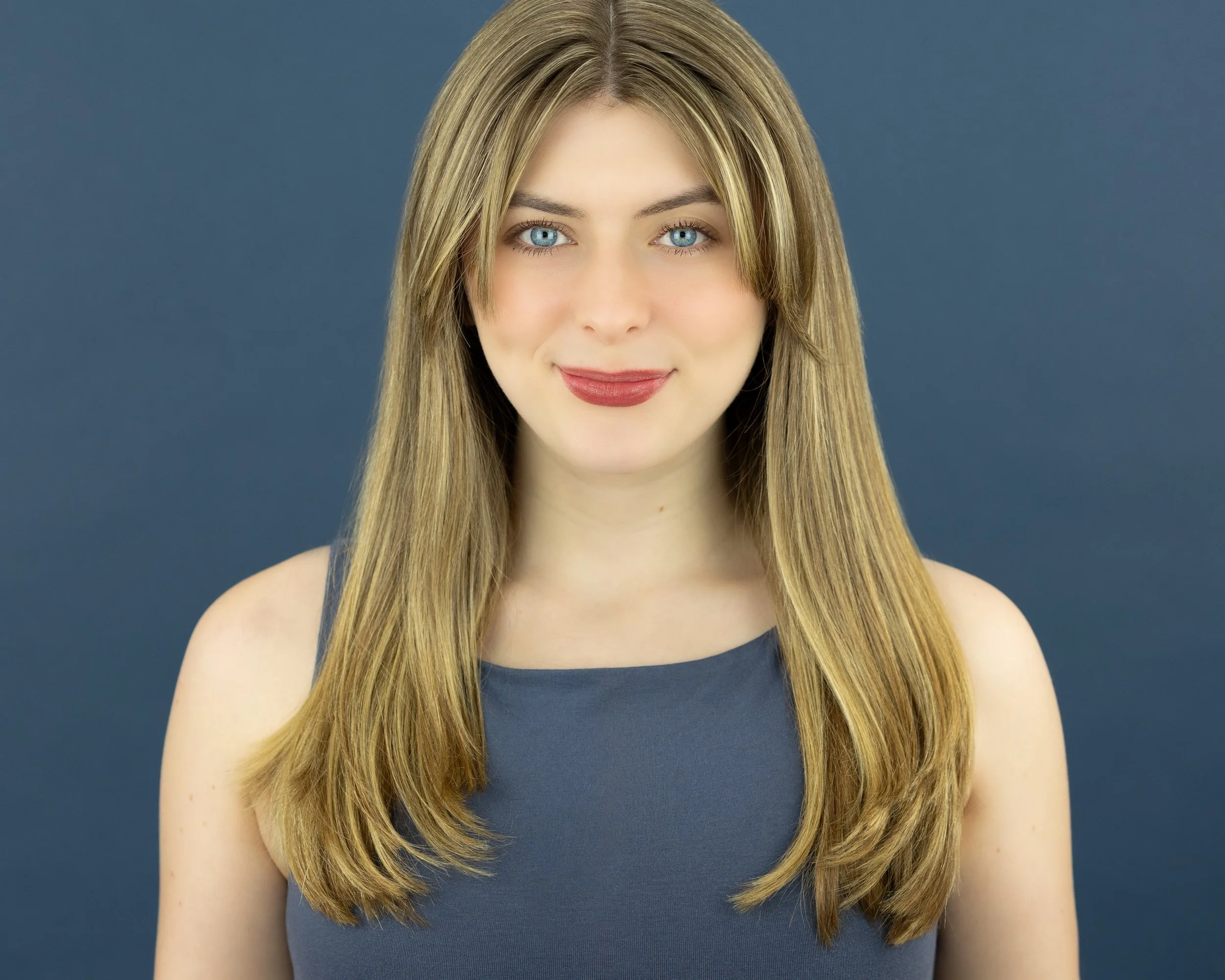 Ruby Griffin, a young blonde girl with blue eyes, in a steel blue top against a steel blue background