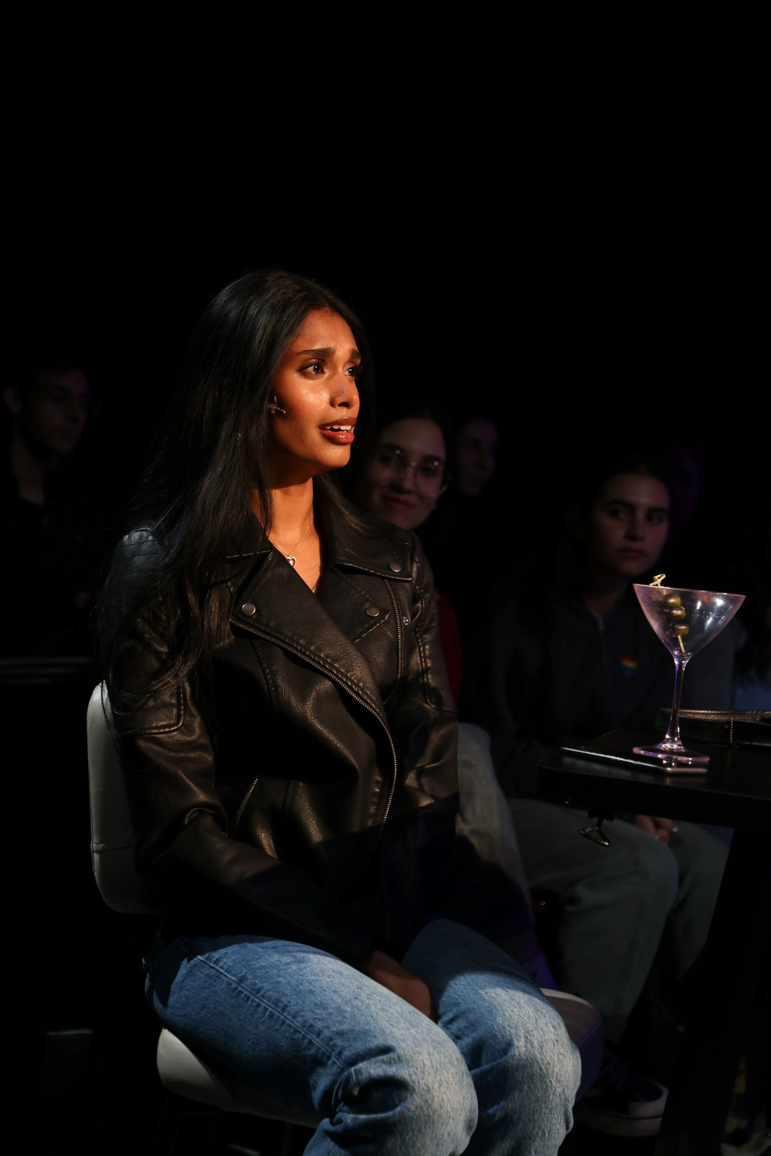 Becky Alex, a young South Asian actress with black hair and dark brown eyes, in a leather jacket and jeans, in NSB's "Love Somebody Now"