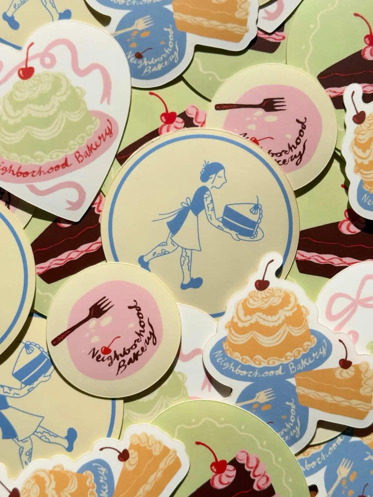 A collage of stickers with different bakery-themed illustrations, including a girl with a cake, slices of cake, and dessert images, all from Neighborhood Bakery.