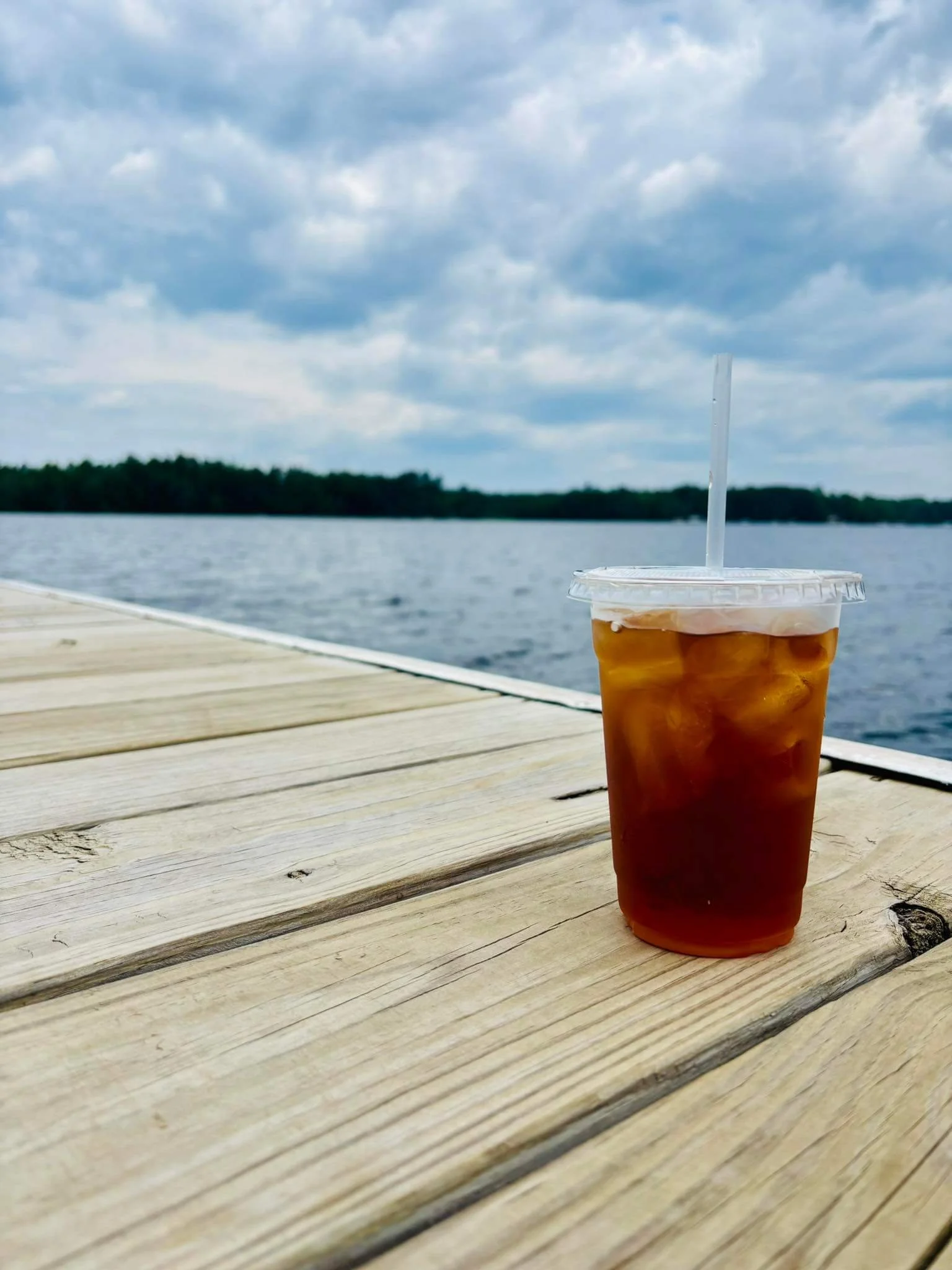 Iced drink on a wooden dock overlooking a lake in Northern Wisconsin, refreshing beverage from a local mobile vendor