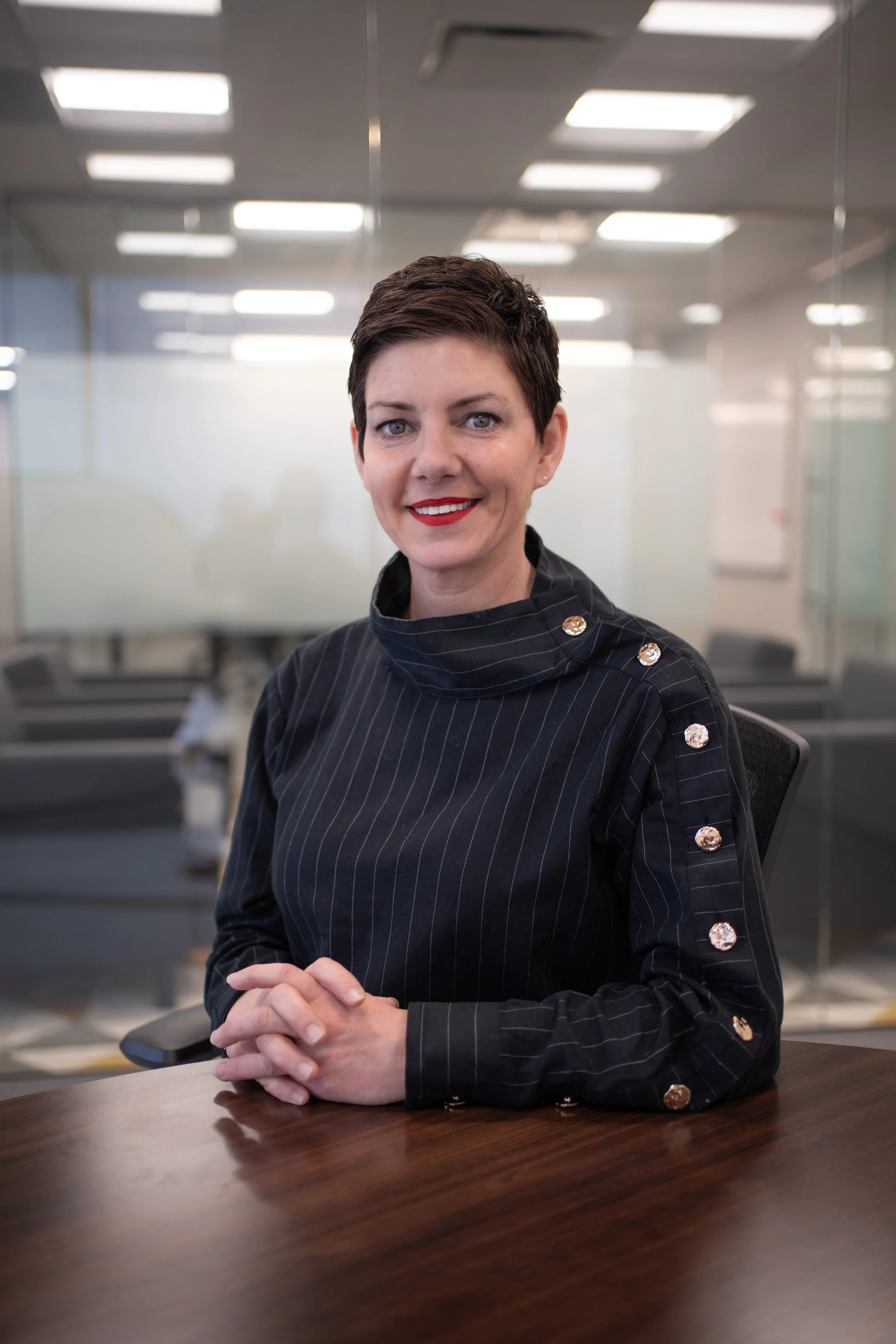 Professional headshot of Dana Vilardi smiling at a conference table in a modern office.