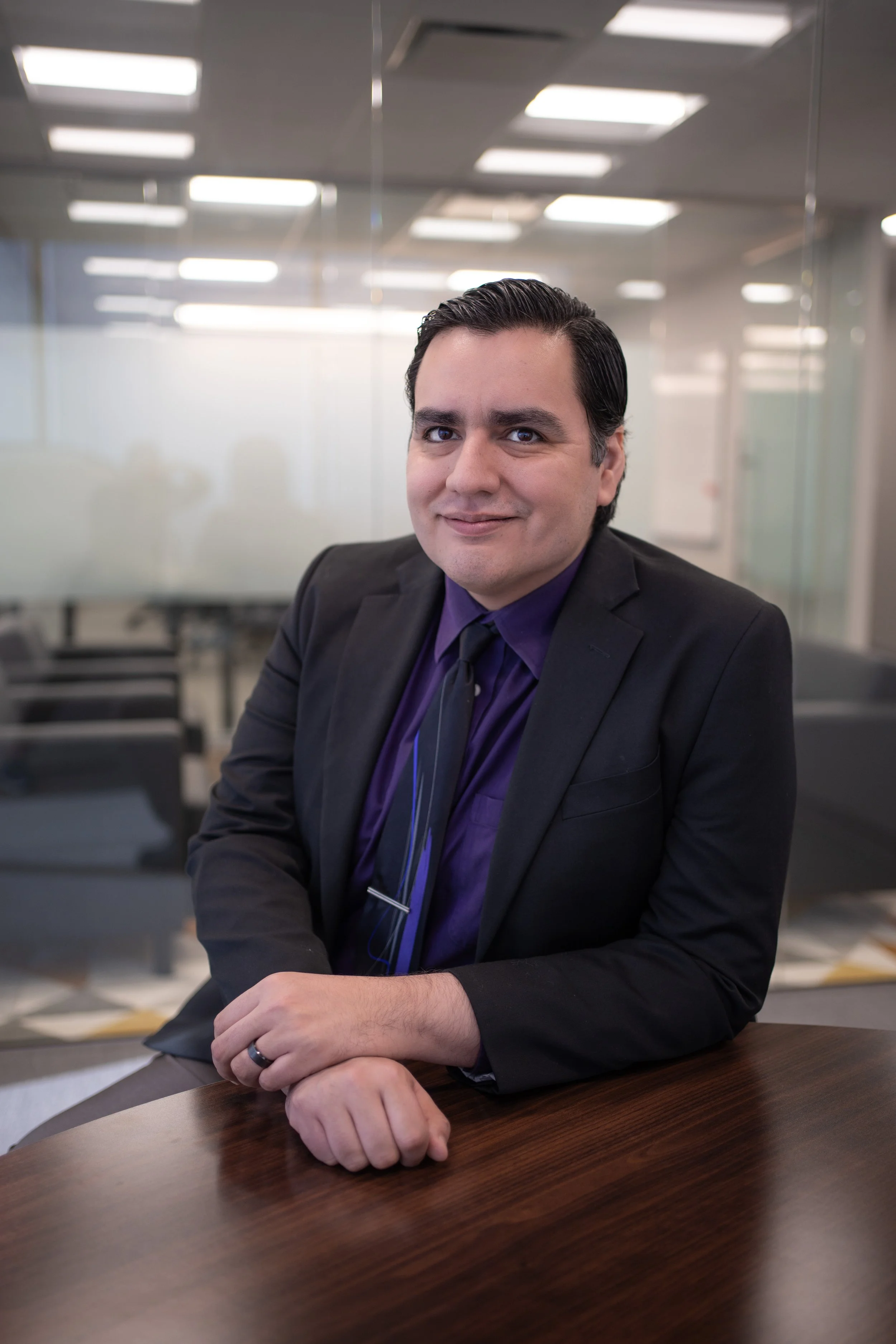 A professional headshot of J. Guillermo Villalobos smiling at a conference table in a modern office.