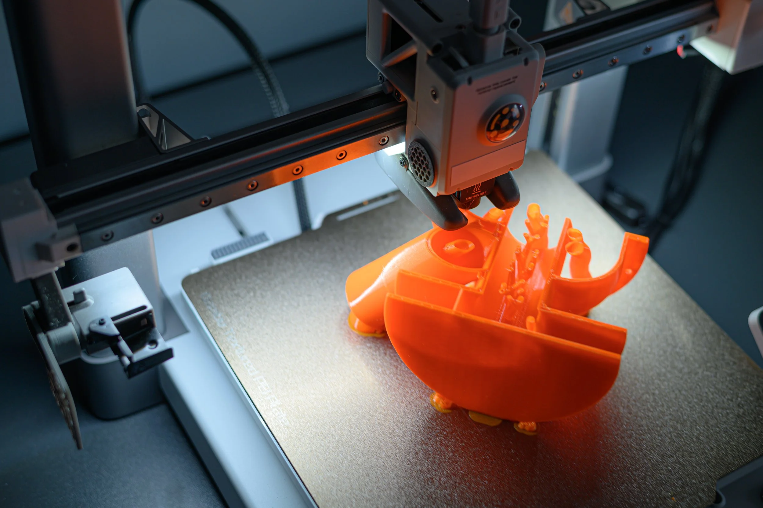3d-printer-creating-intricate-orange-object-2026-01-07-06-40-31-utc.jpg