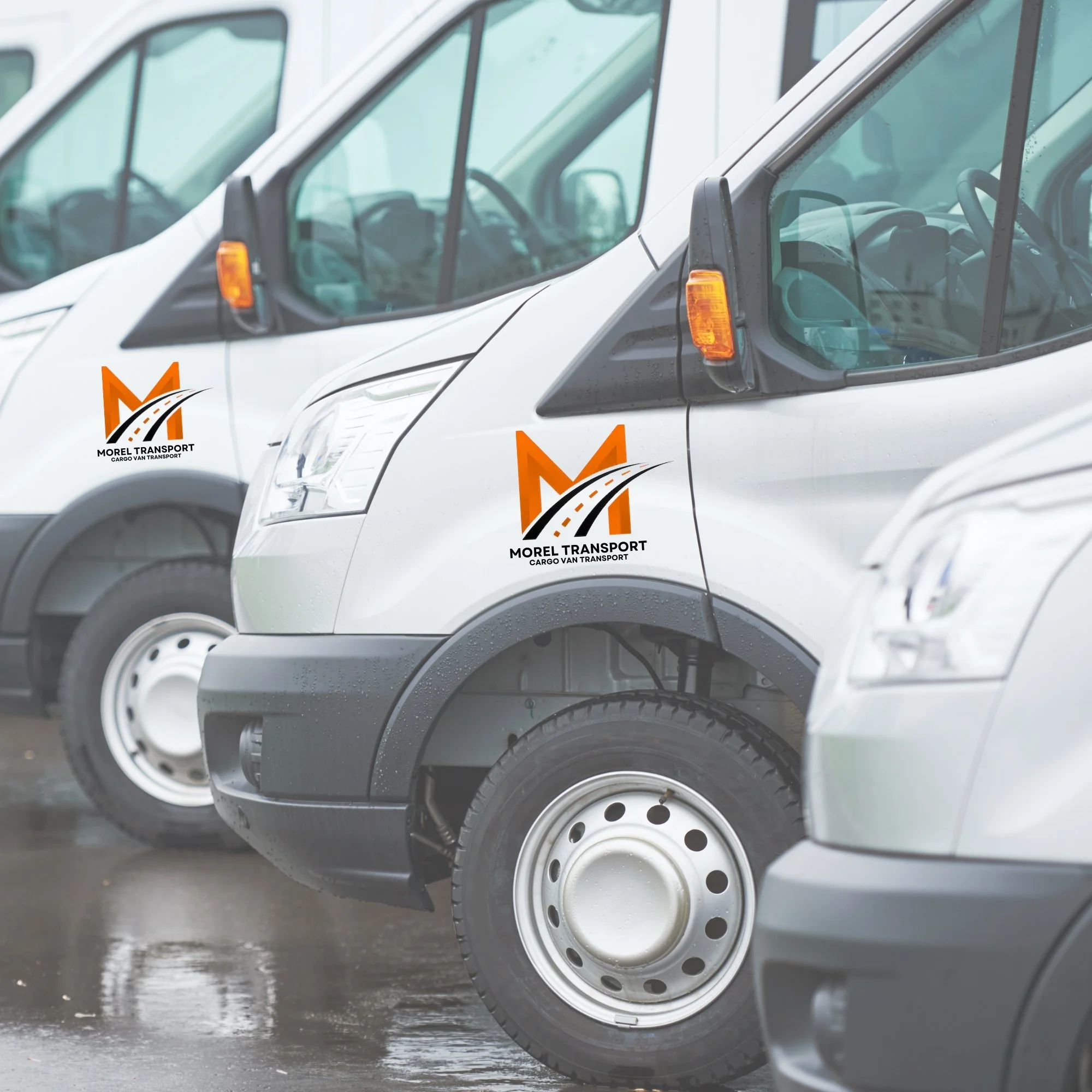 Cargo vans with the Morel Transport logo parked in a row on a rainy day.