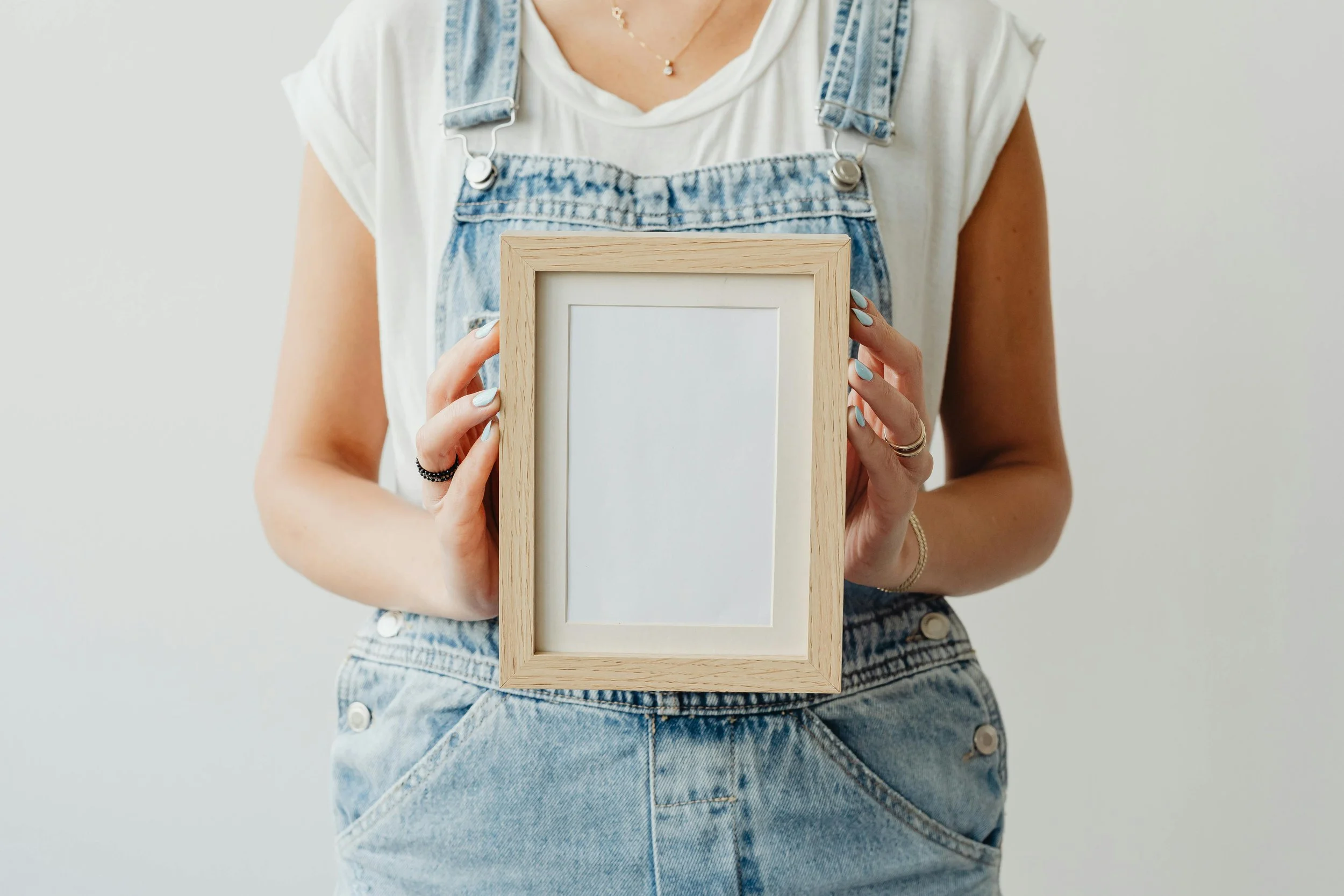 An individual holding a blank frame to symbolize the blank slate of therapy.
