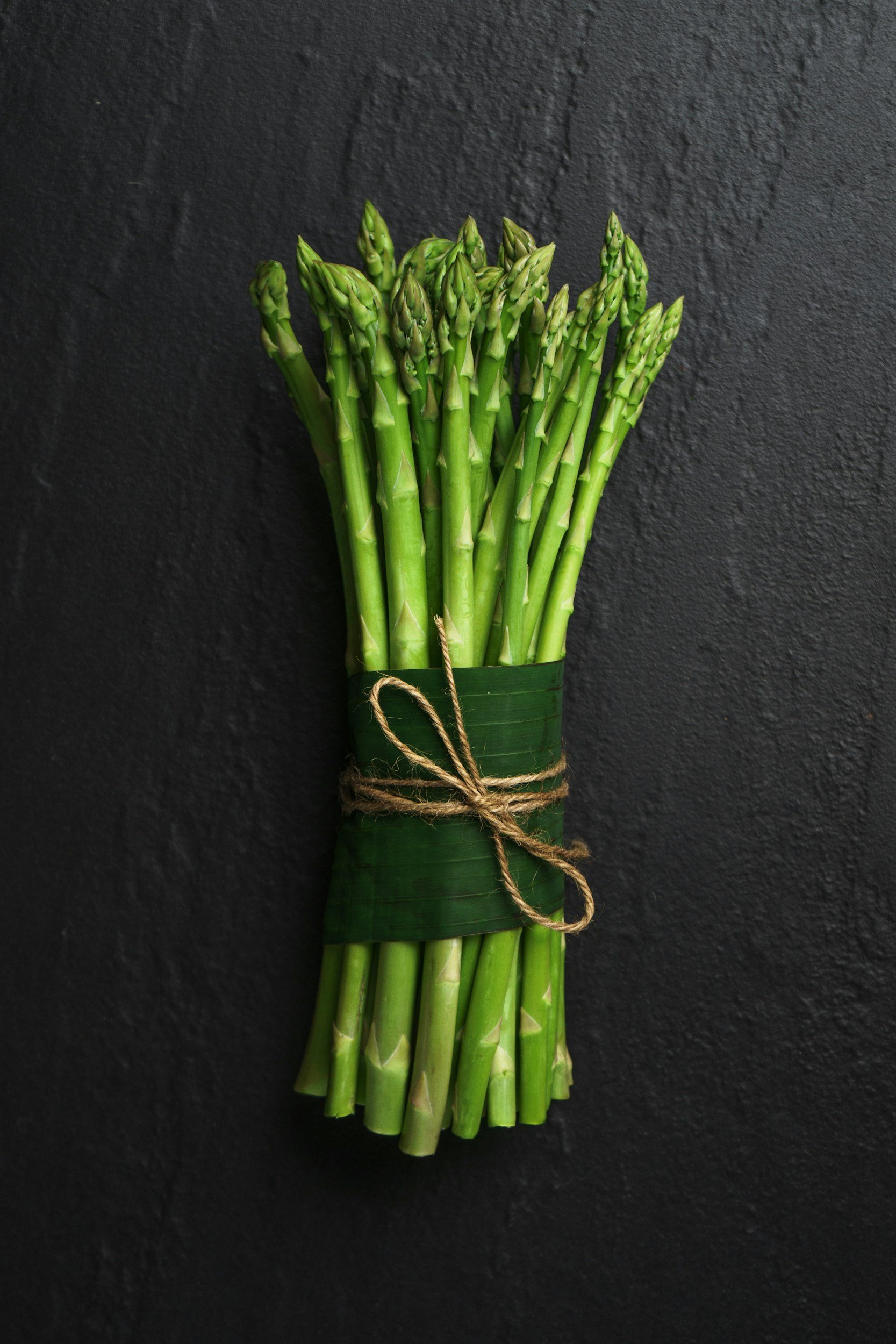 Fresh asparagus bundled with twine, highlighting a seasonal, ingredient-driven approach to cooking.