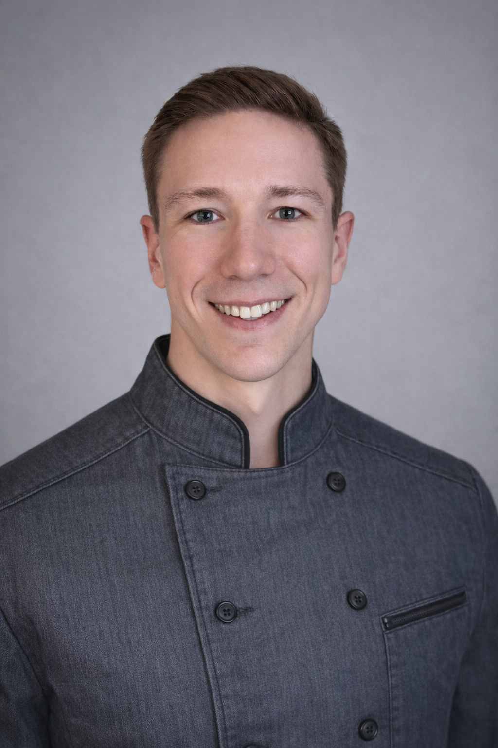 Private chef David Bisenius in a modern chef coat, reflecting a refined and approachable style.