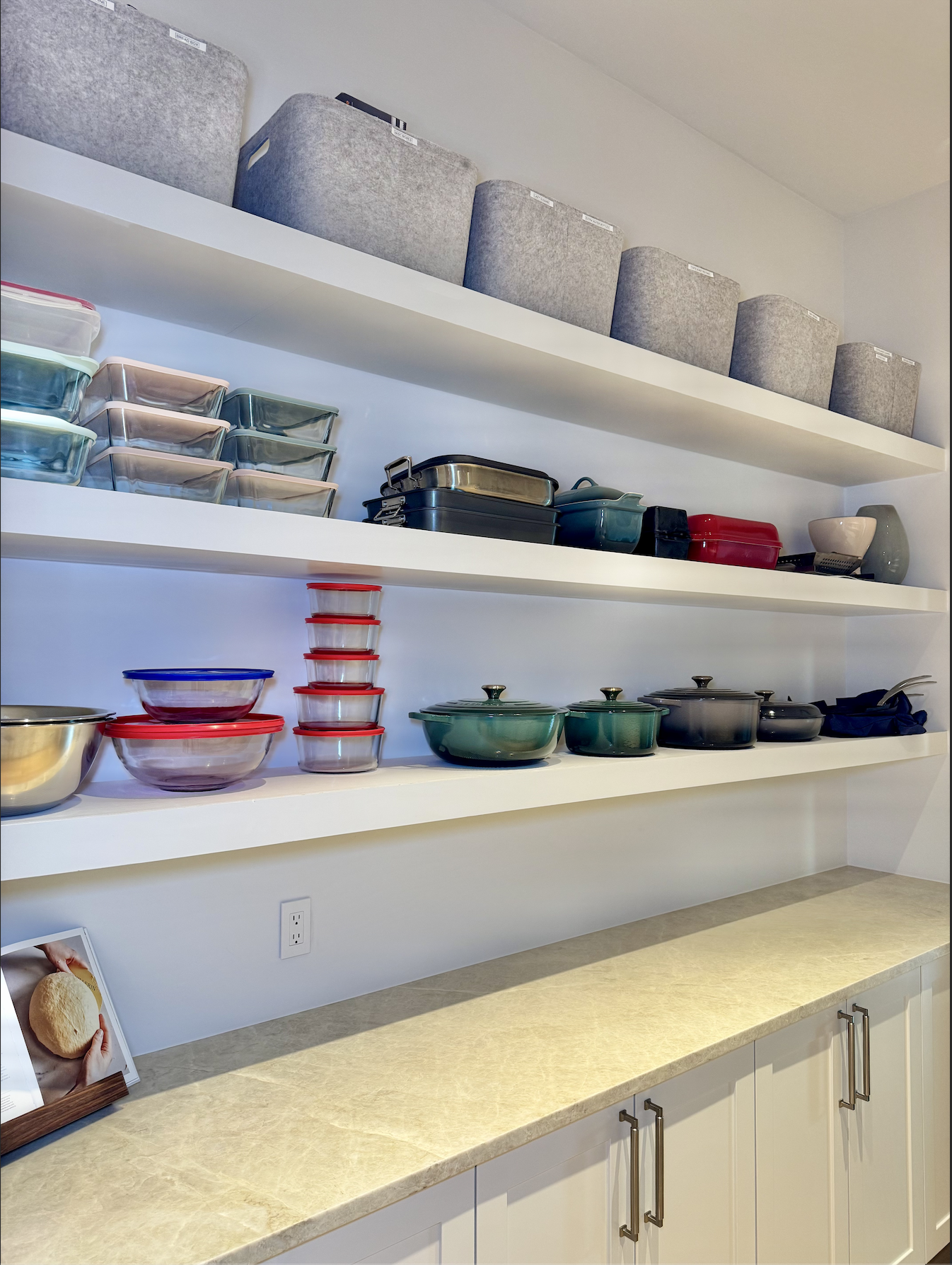 Organized kitchen pantry with categorized shelving and bins for tupperware, pots, and pans — professional pantry organization by Ordered Living Co. Austin TX