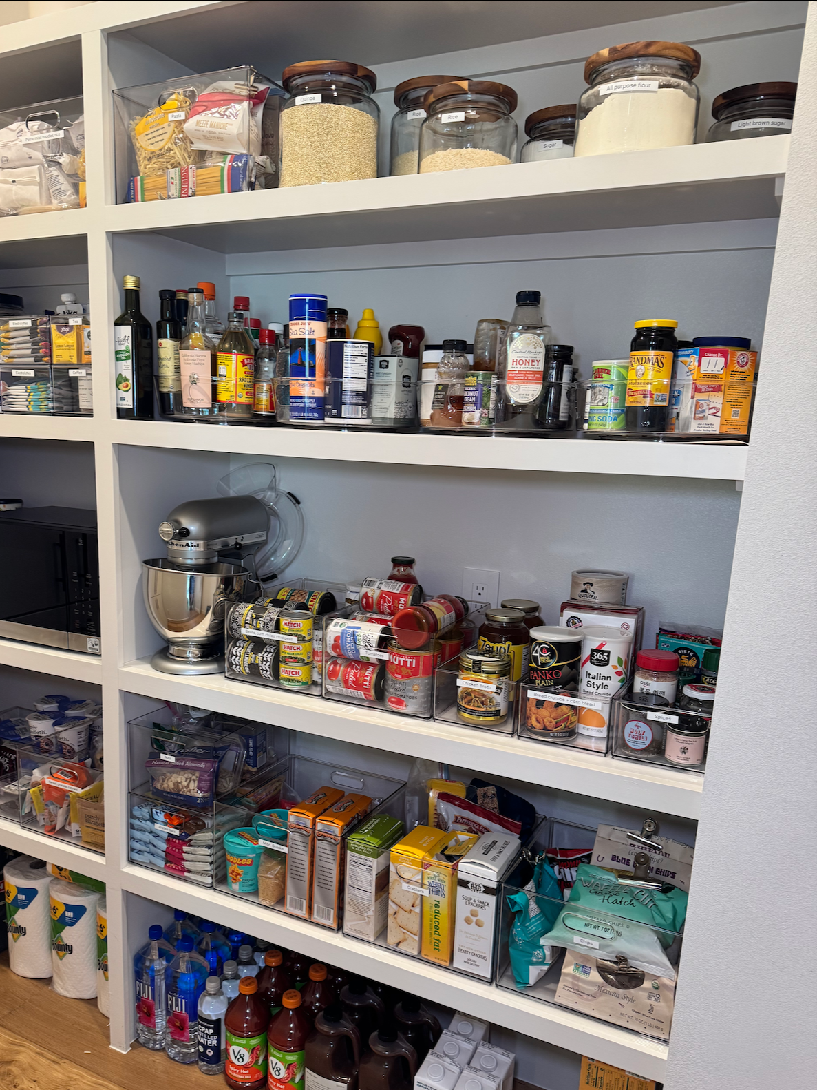 Full pantry organization with labeled jars, categorized food items, and appliance storage — professional home organizer Austin TX