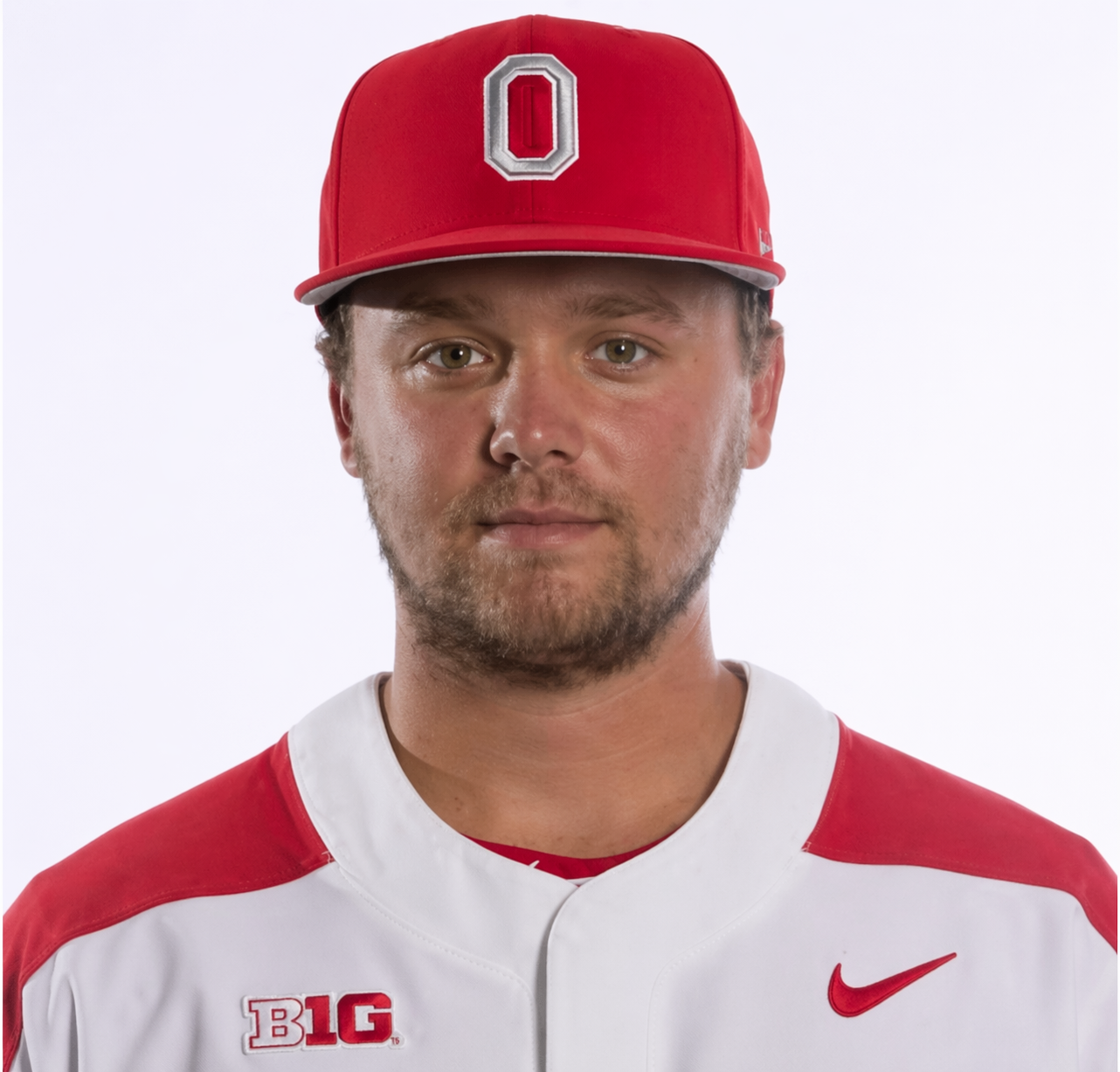 Portrait of a male athlete wearing a red baseball cap with a gray and red Ohio State logo, a white and red Nike sports jersey with 'B1G' patch, against a plain white background.