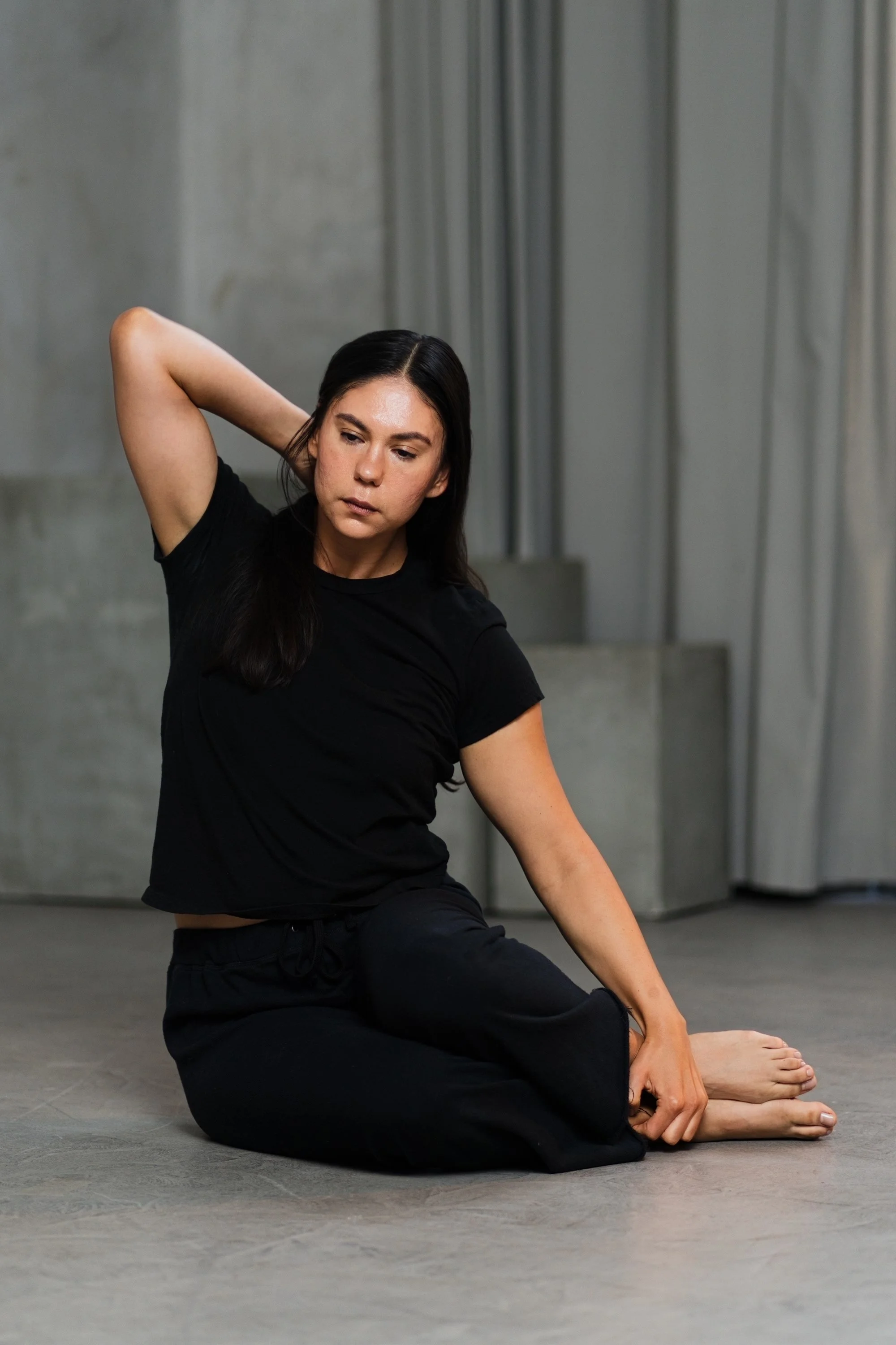 A woman performing a classical Pilates Side Bend variation.