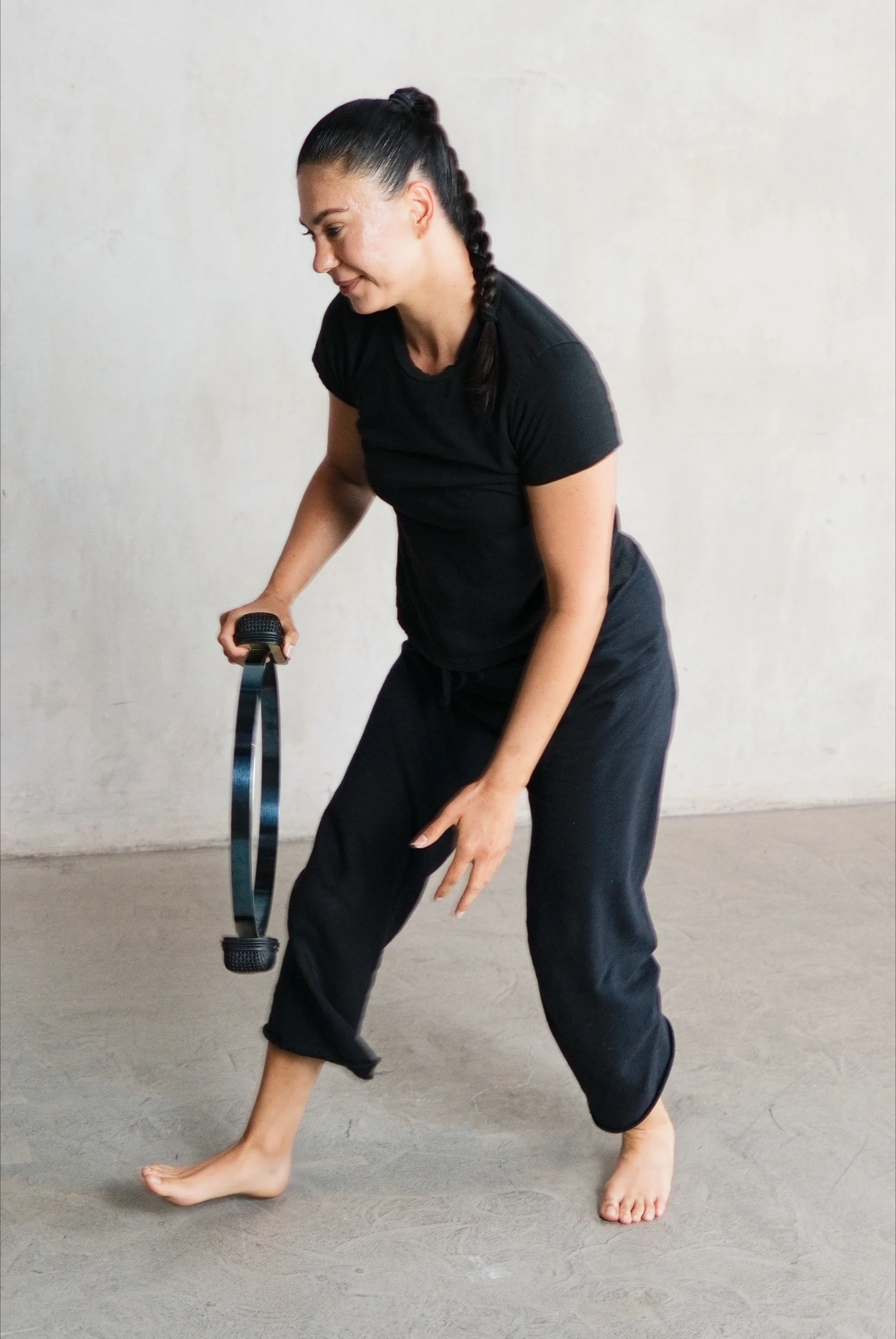 A woman setting up a classical Pilates class with a Contrology Magic Circle.