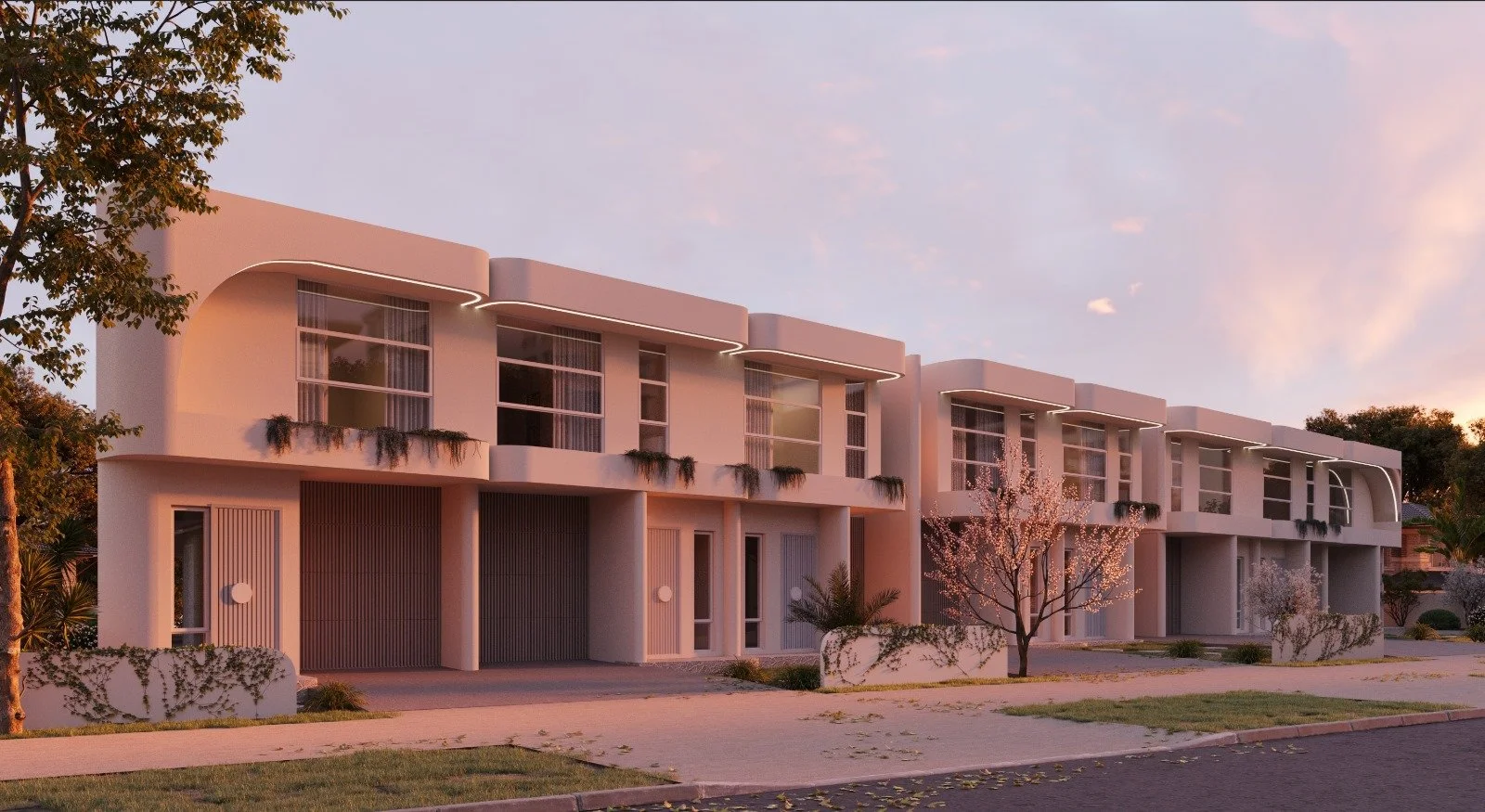 Modern white residential buildings with curved balconies, situated along a sidewalk with trees and landscaped areas at sunset.