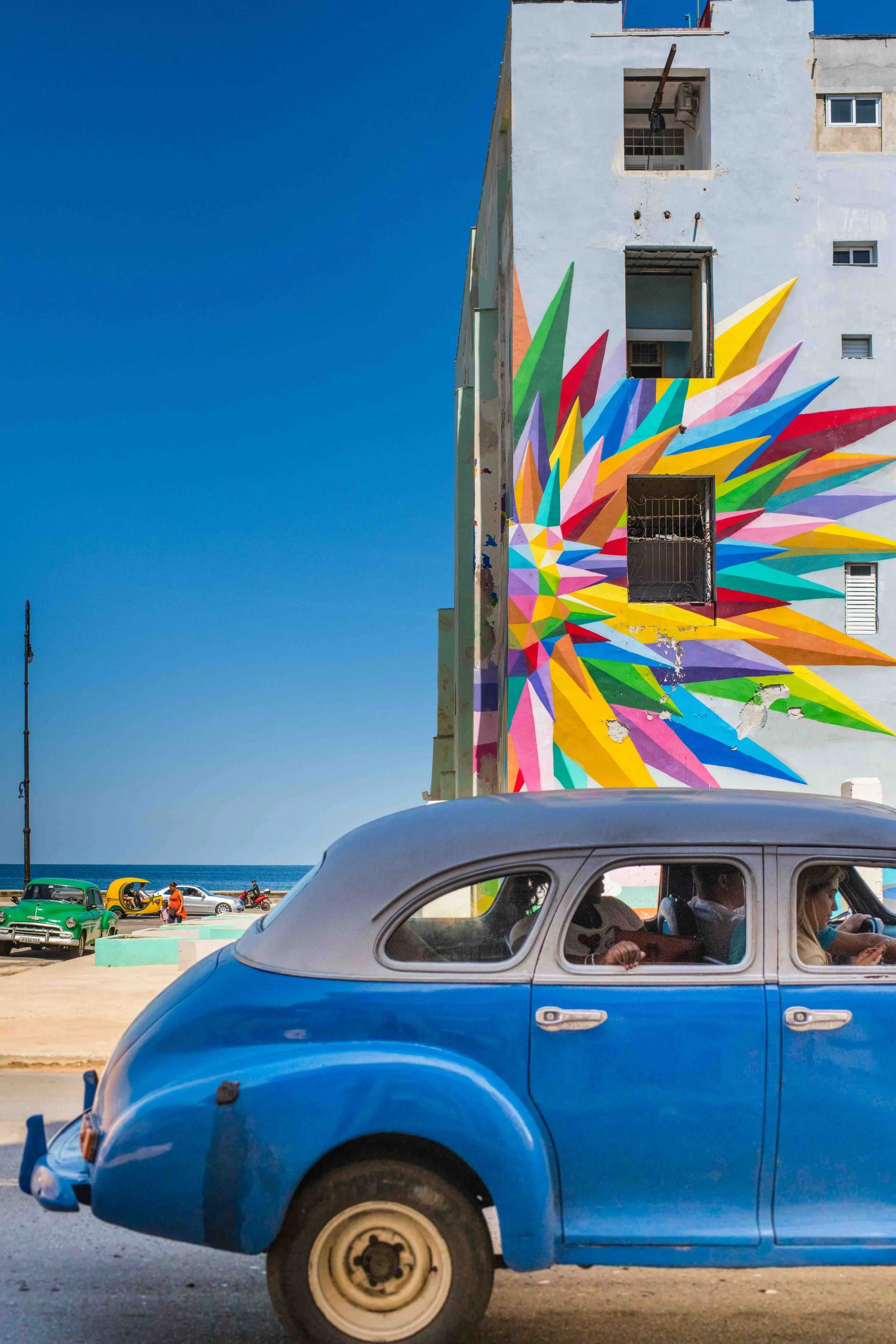 Colorful building in Havana Cuba with Blue Car