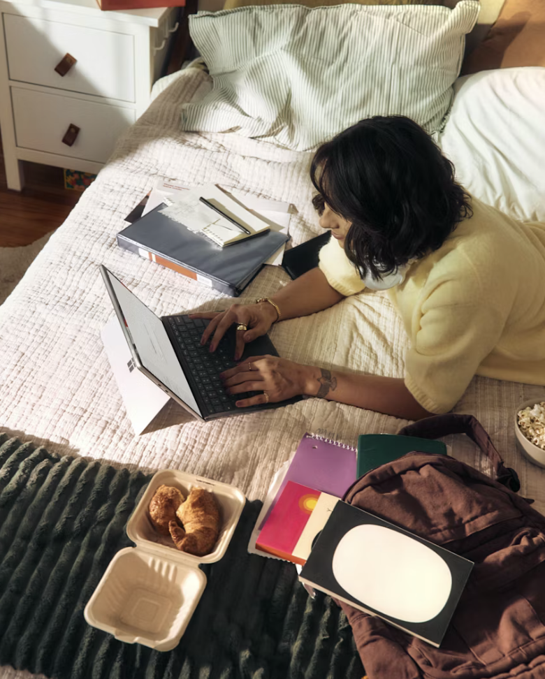 Woman on bed browsing the internet on a tablet