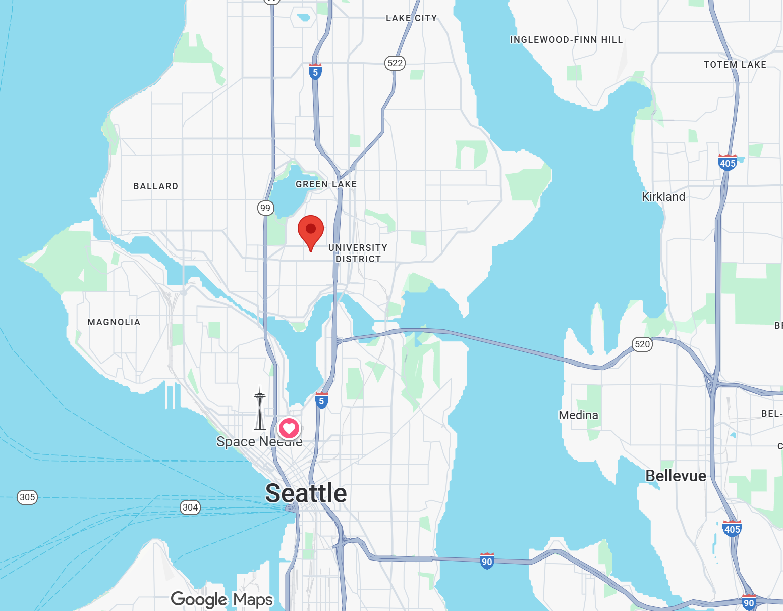 Map of Seattle, Washington with markers indicating specific locations: a red marker in the University District, a pink heart marker at Space Needle, and a location icon at Green Lake. Nearby lakes, highways, and neighborhoods are also visible.