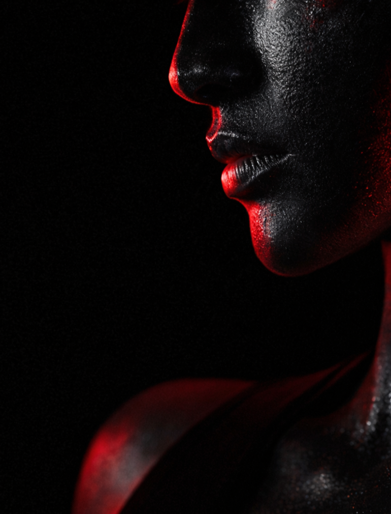 Close-up of a person's face with water droplets, illuminated by red light, showing lips and part of the nose against a dark background.