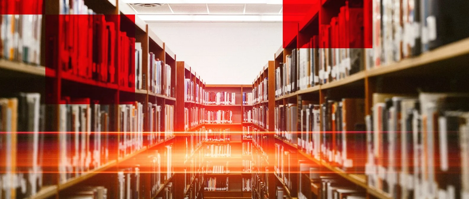 A library aisle with wooden shelves filled with books. The photo has red overlay and lines indicating scanning or focus areas.
