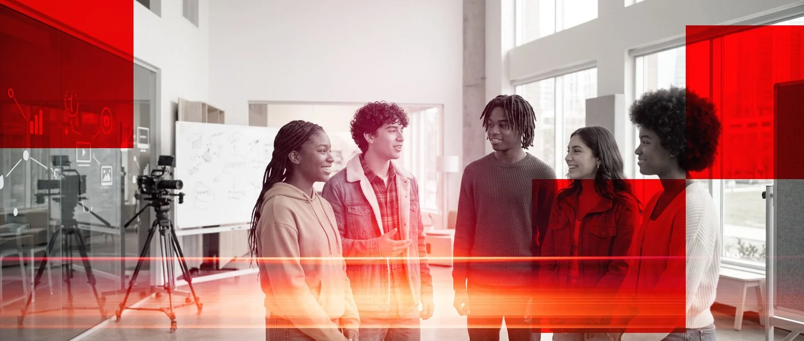A group of five young people engaging in a discussion or interview inside a well-lit room with large windows, cameras, and filming equipment in the background.