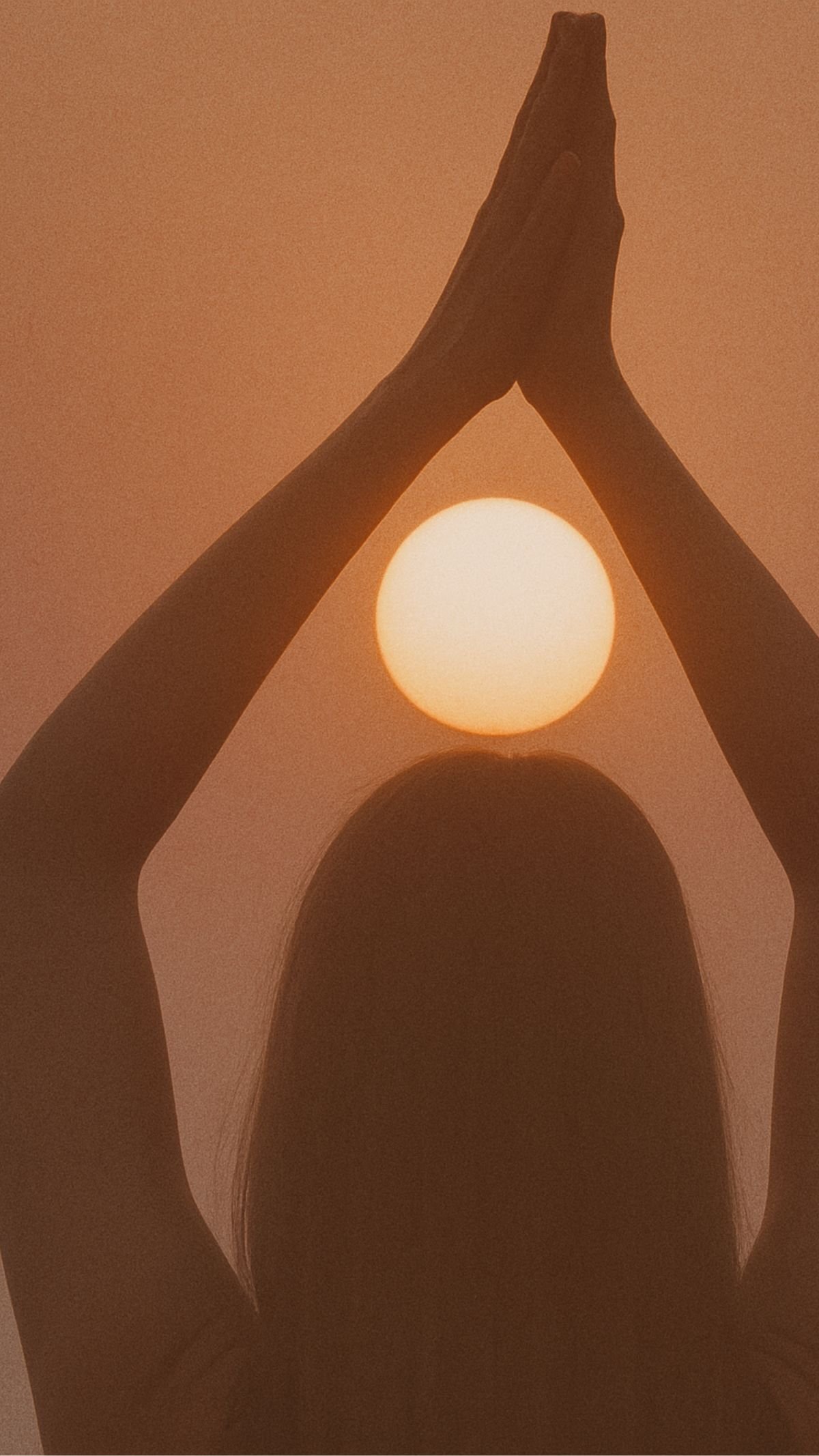 Une silhouette humaine avec les bras levés en forme de triangle, avec le soleil en arrière-plan dans un ciel orangé.