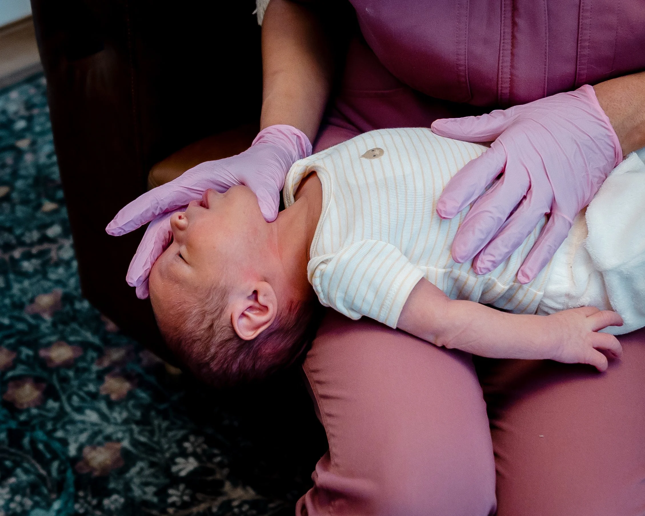Jacklynn Knotts is showing a newborn in a guppy position on her lap to improve tethered oral ties, breast or bottle feeding challenges, and more at Tiny Feeding Co. in El Paso, TX.
