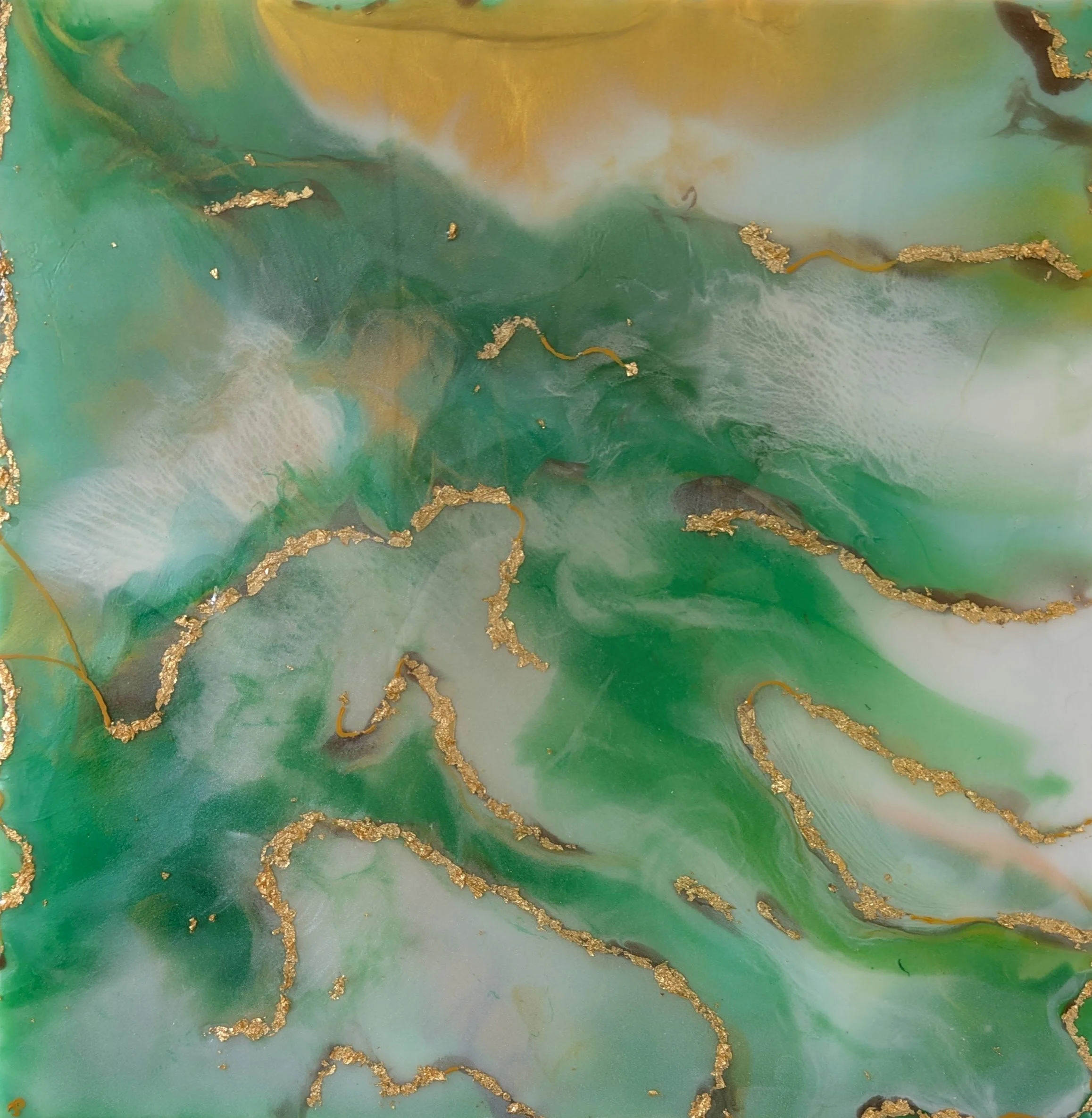 A close-up image of an abstract painting with swirls of green, gold, white, and hints of yellow, with textured gold accents scattered throughout.