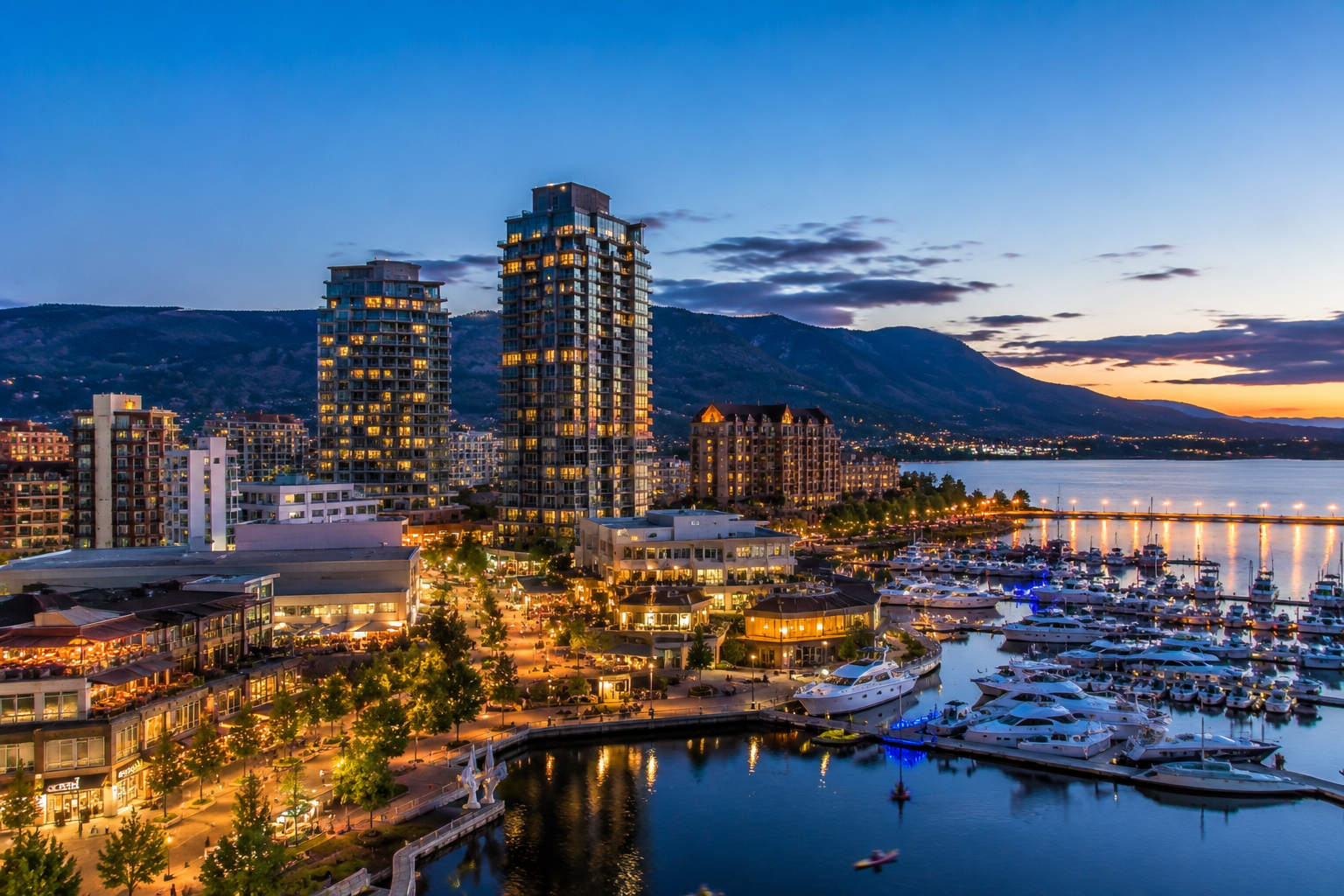 Downtown Kelowna, British Columbia with modern buildings, a vibrant waterfront, marina, Okanagan Lake, and surrounding mountains, representing Mr. Marble and Stone’s Kelowna service area.