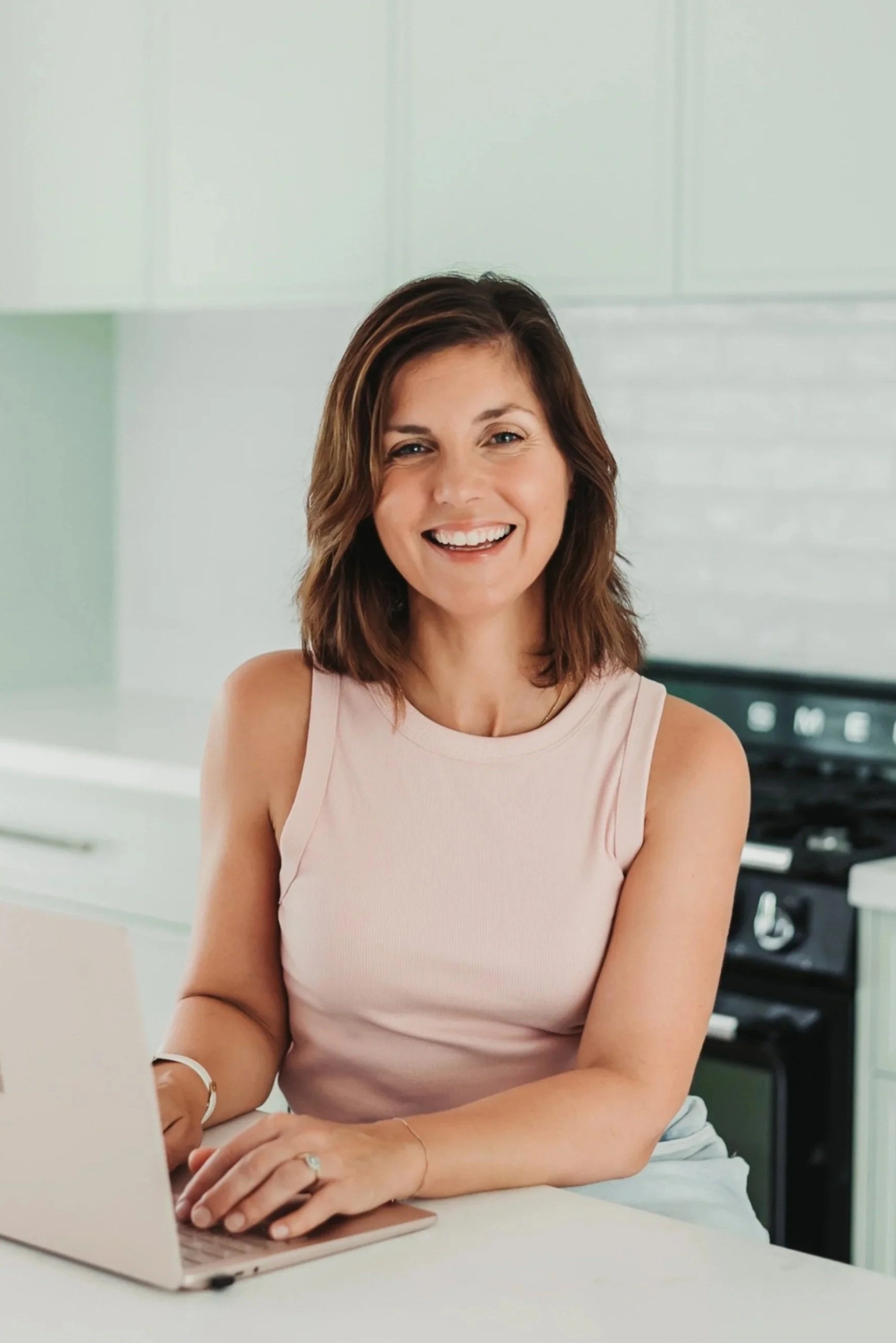 Counsellor EFT Practitioner Heather Ferry smiles warmly sat at laptop