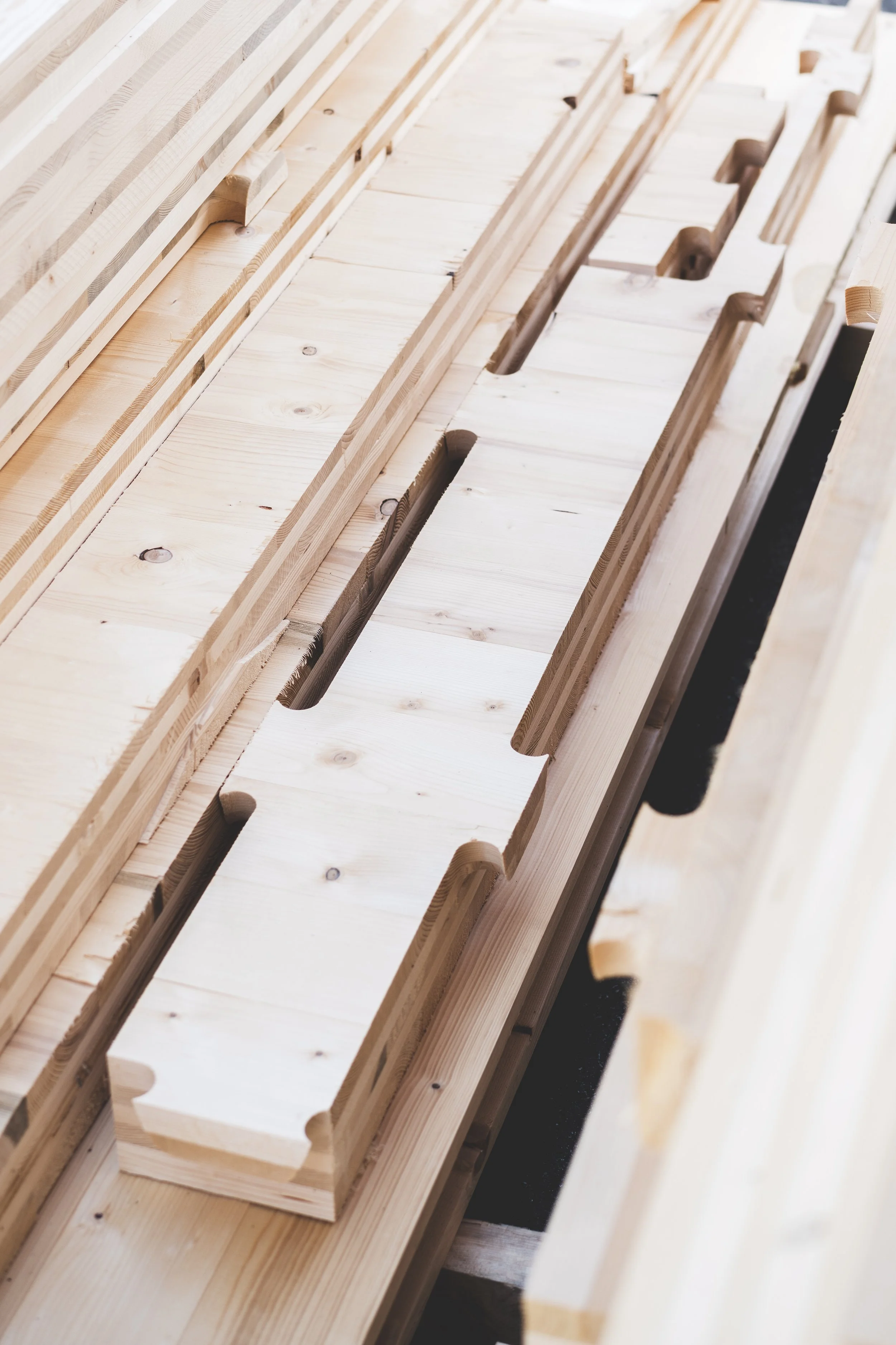 Mehrere Holzbretter und Holzstücke sind in einer Werkstatt oder auf einer Baufläche zum Bau eines Möbelstücks oder Hauses ausgelegt.