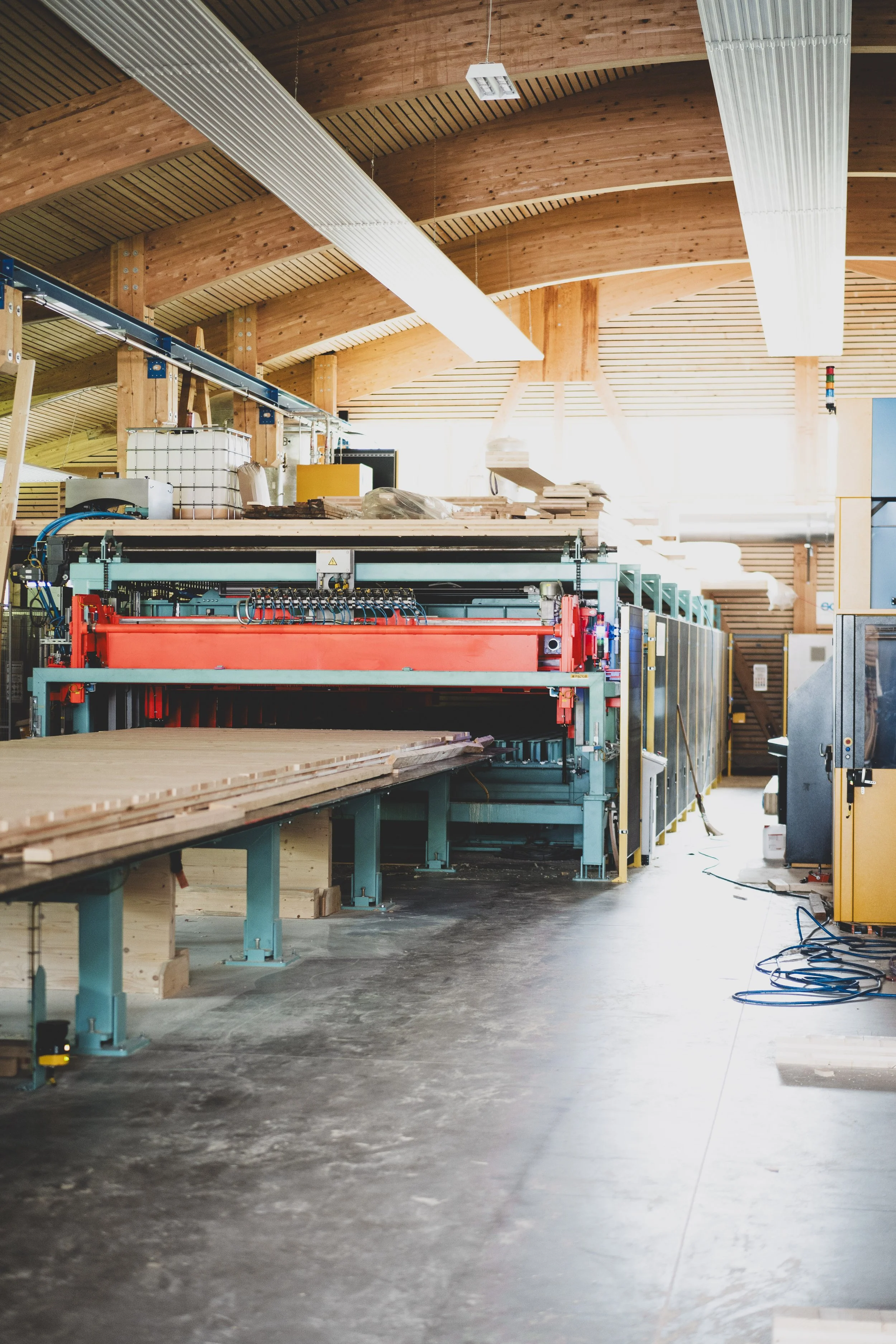 Innenansicht einer Werkstatt oder Fabrikhalle mit Holzstrukturen und maschinellen Einrichtungen.